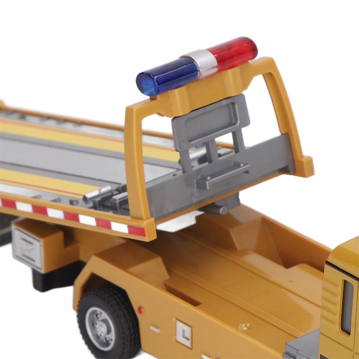 Gelber Spielzeug-LKW mit rotem und blauem Licht oben. Es ist ein Abschleppwagen.