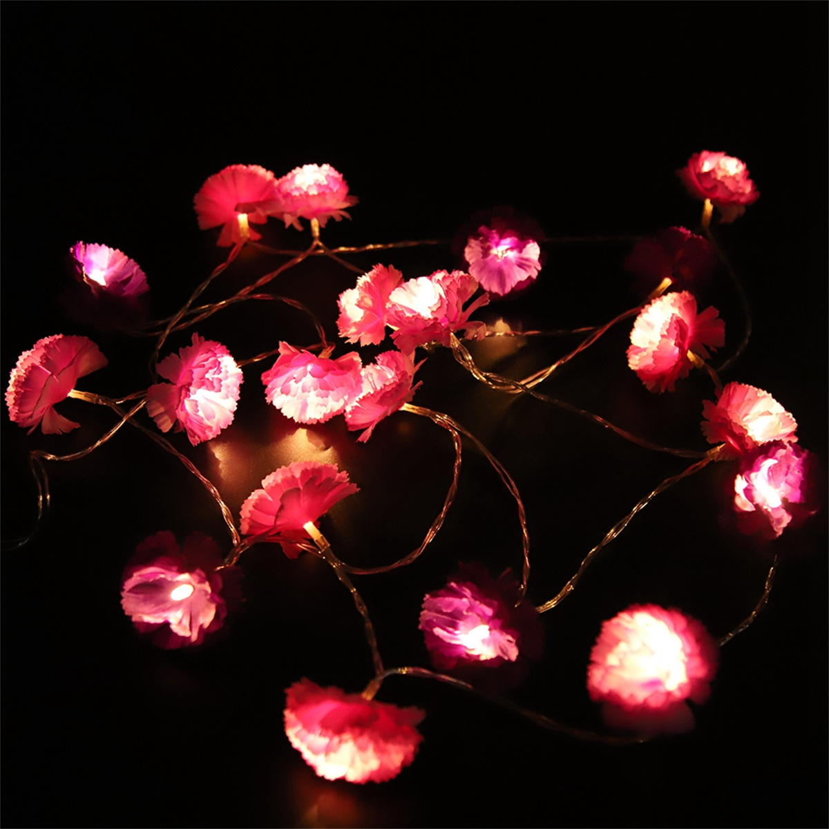 Rosa Blumengirlanden auf dunklem Hintergrund. Die Lichter beleuchten jede rosa Blume.