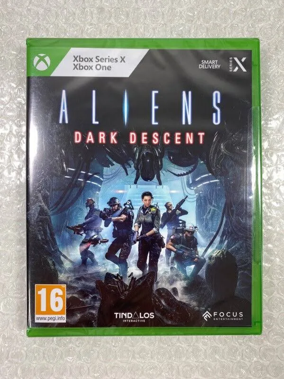 Spielbox von 'Aliens: Dark Descent' mit grünem Rand. Soldaten sind auf dem Cover.