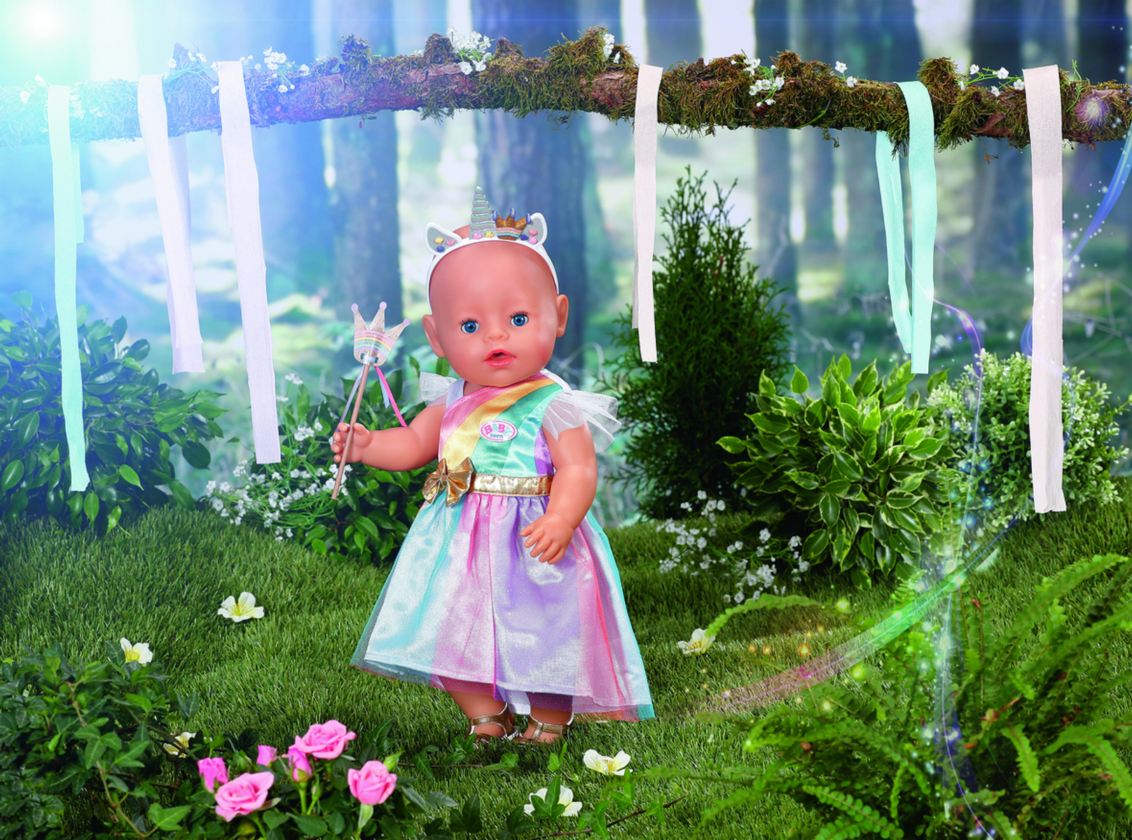Babypuppe in einem Einhornkleid, mit Zauberstab, in einer Waldumgebung mit Blumen. Natürliche Beleuchtung.