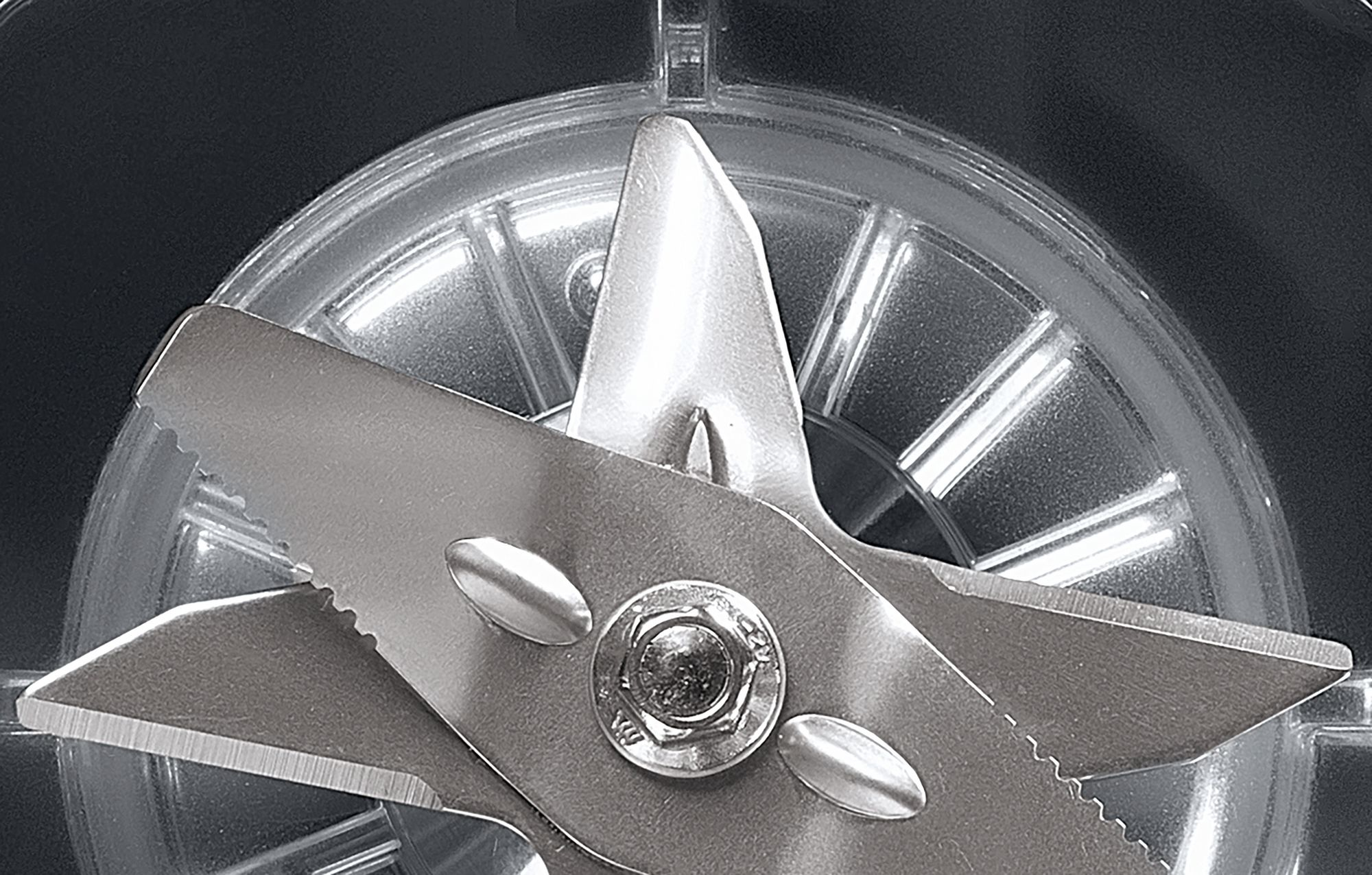 Zbliżenie głowicy nożyc wieloostrzowych na rozmytym tle.