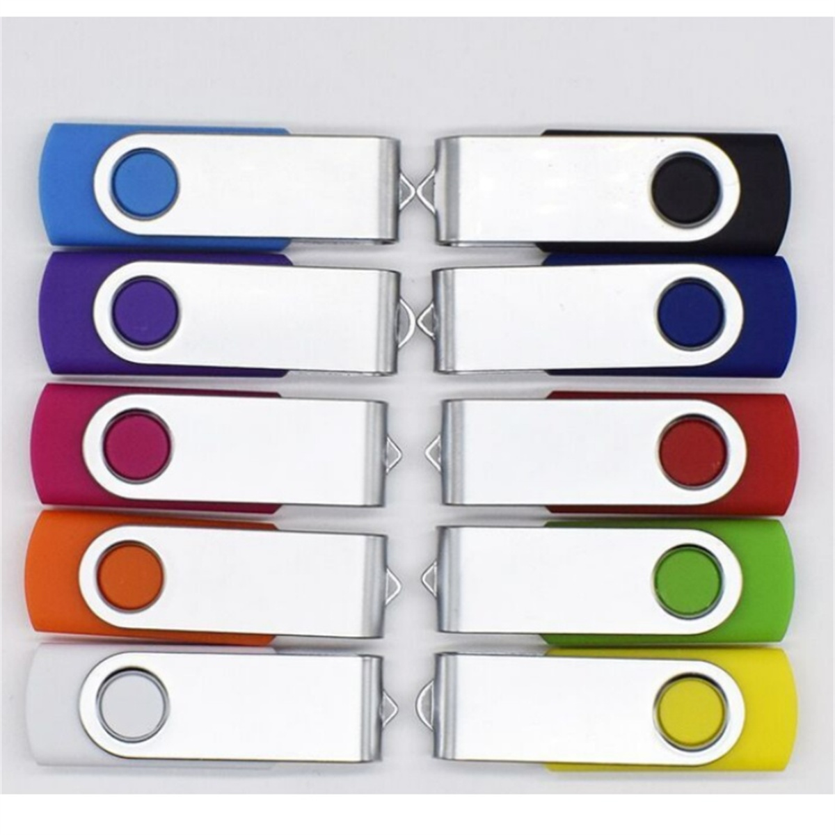 Zehn USB-Sticks in verschiedenen Farben sind in zwei Reihen auf einer weißen Oberfläche angeordnet.
