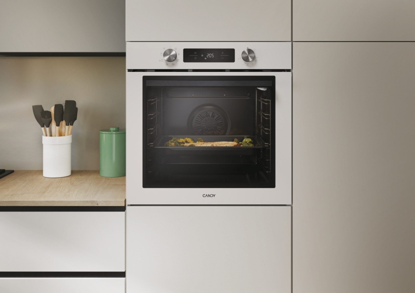 Forno bianco in un ambiente cucina moderno. Il forno è aperto e ha un vassoio di cibo all'interno.