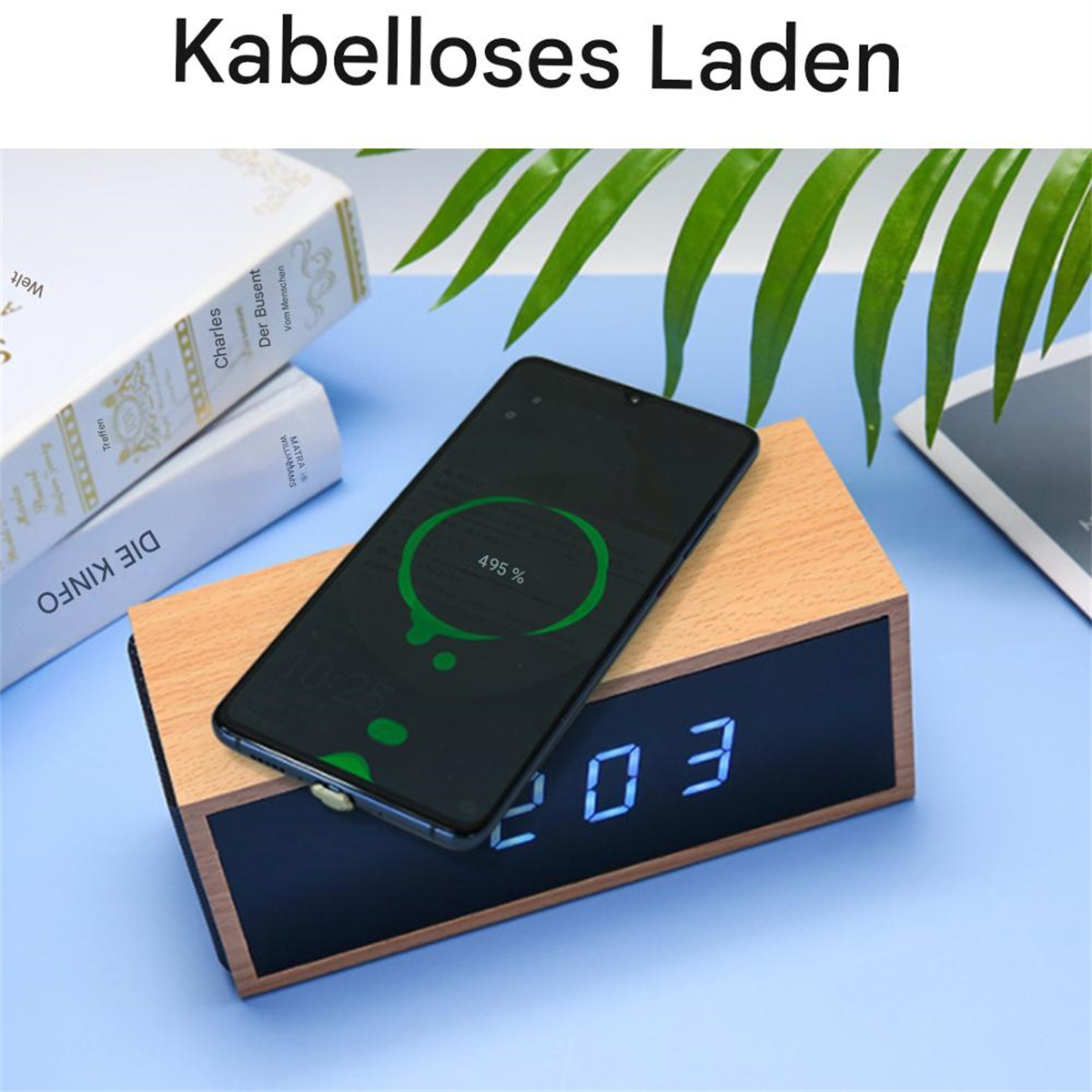 Ein Telefon, das auf einem hölzernen Ladegerät mit blauer Oberfläche geladen wird, mit Büchern und einer Pflanze.