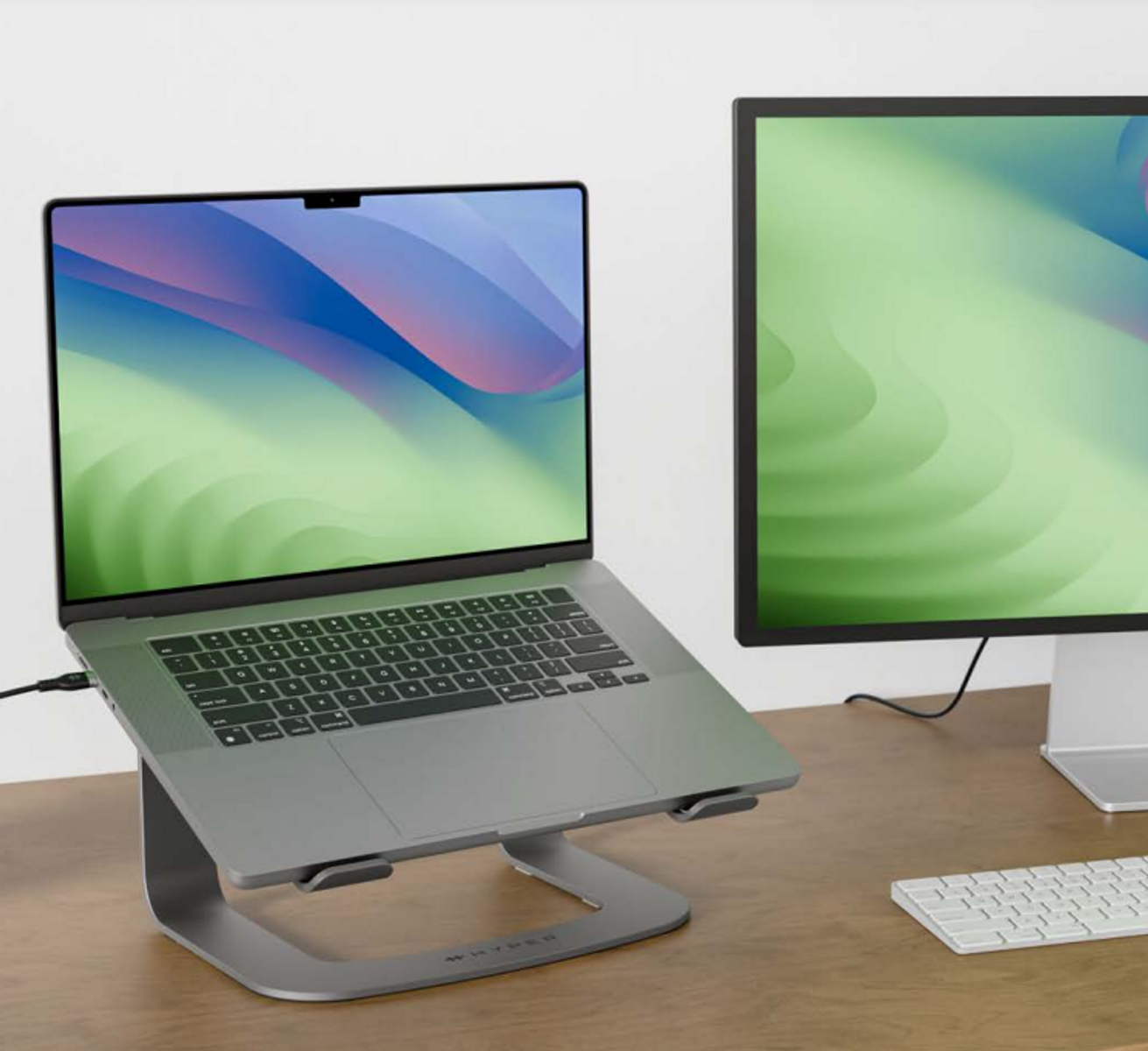 Laptop und Monitor auf einem Schreibtisch, verbunden mit einem Laptop-Ständer.