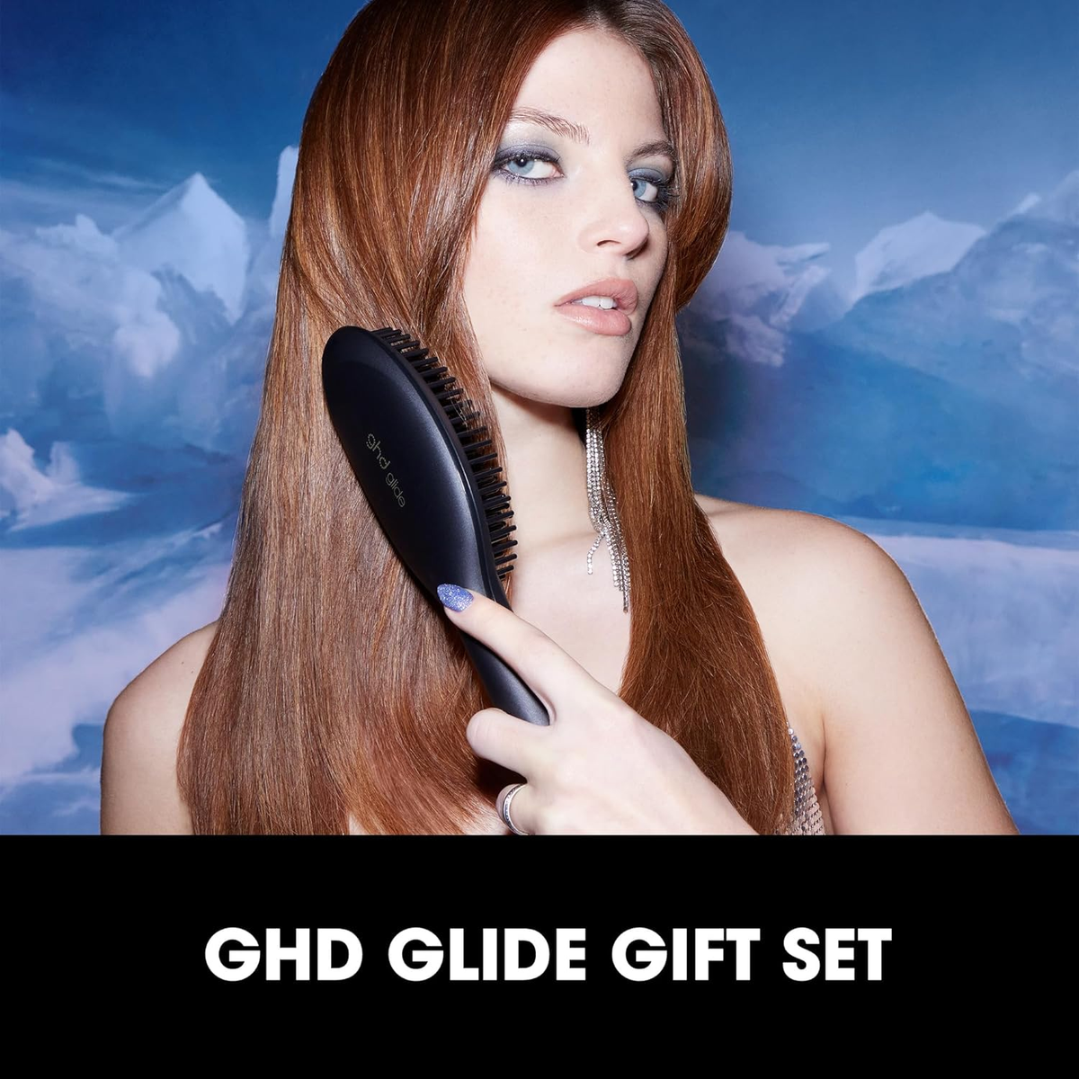 Una donna che si spazzola i lunghi capelli rossi con una spazzola GHD Glide nera, GHD Glide Gift Set in mostra.