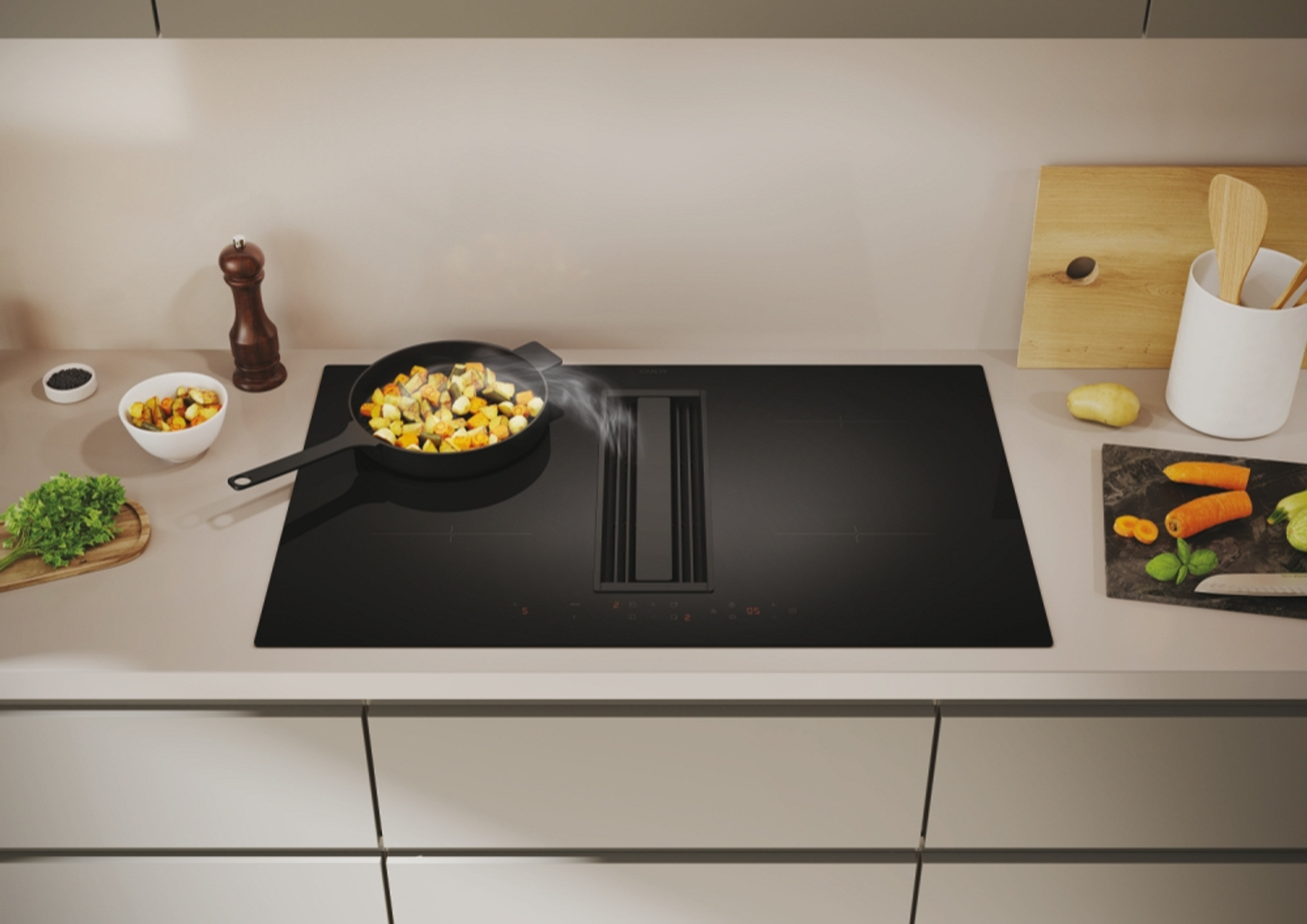 Cucina con piano cottura a induzione nero con ventilazione integrata, verdure fritte e vari utensili da cucina.