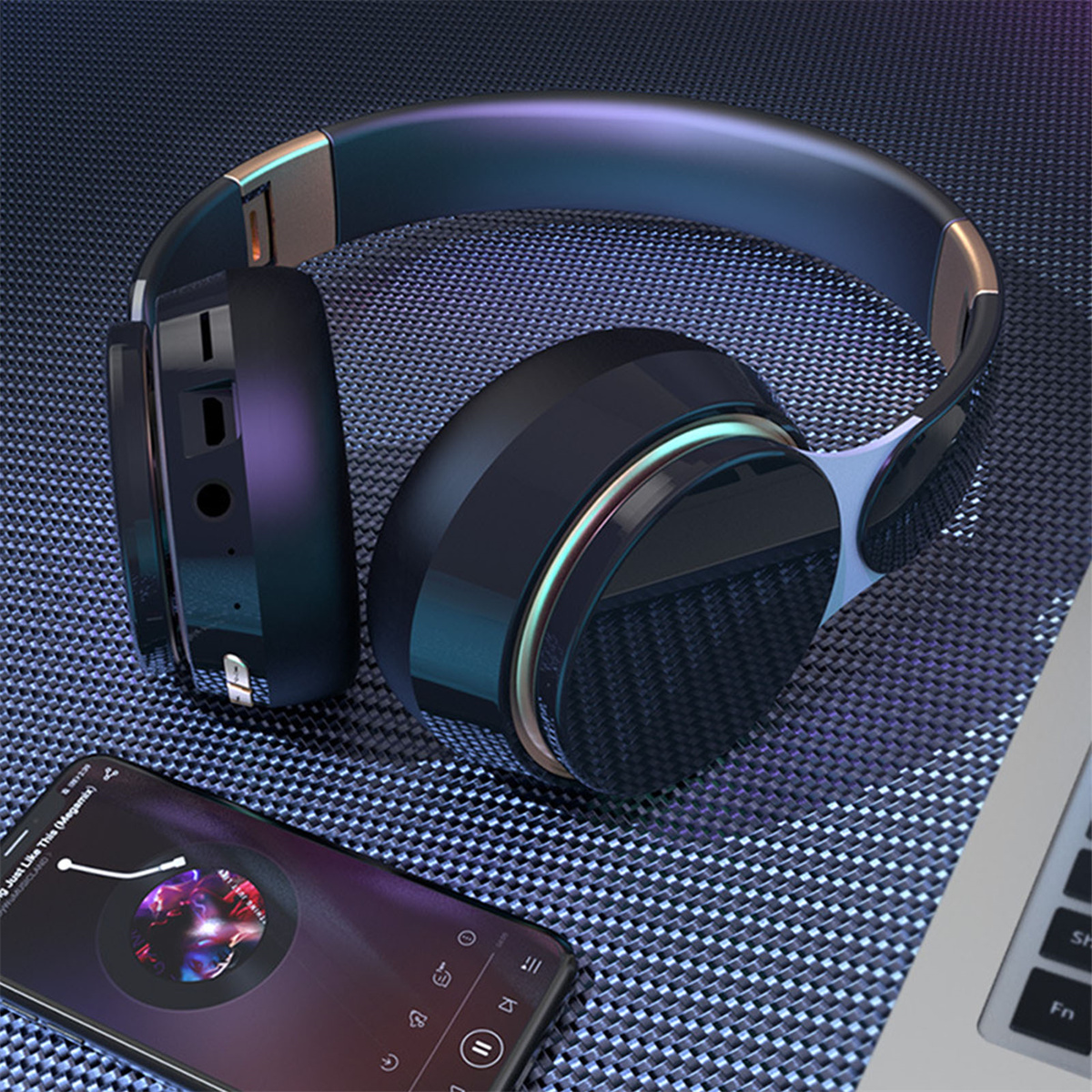 Schwarze Kopfhörer auf einer Oberfläche, in der Nähe eines Smartphones, das Musik abspielt.
