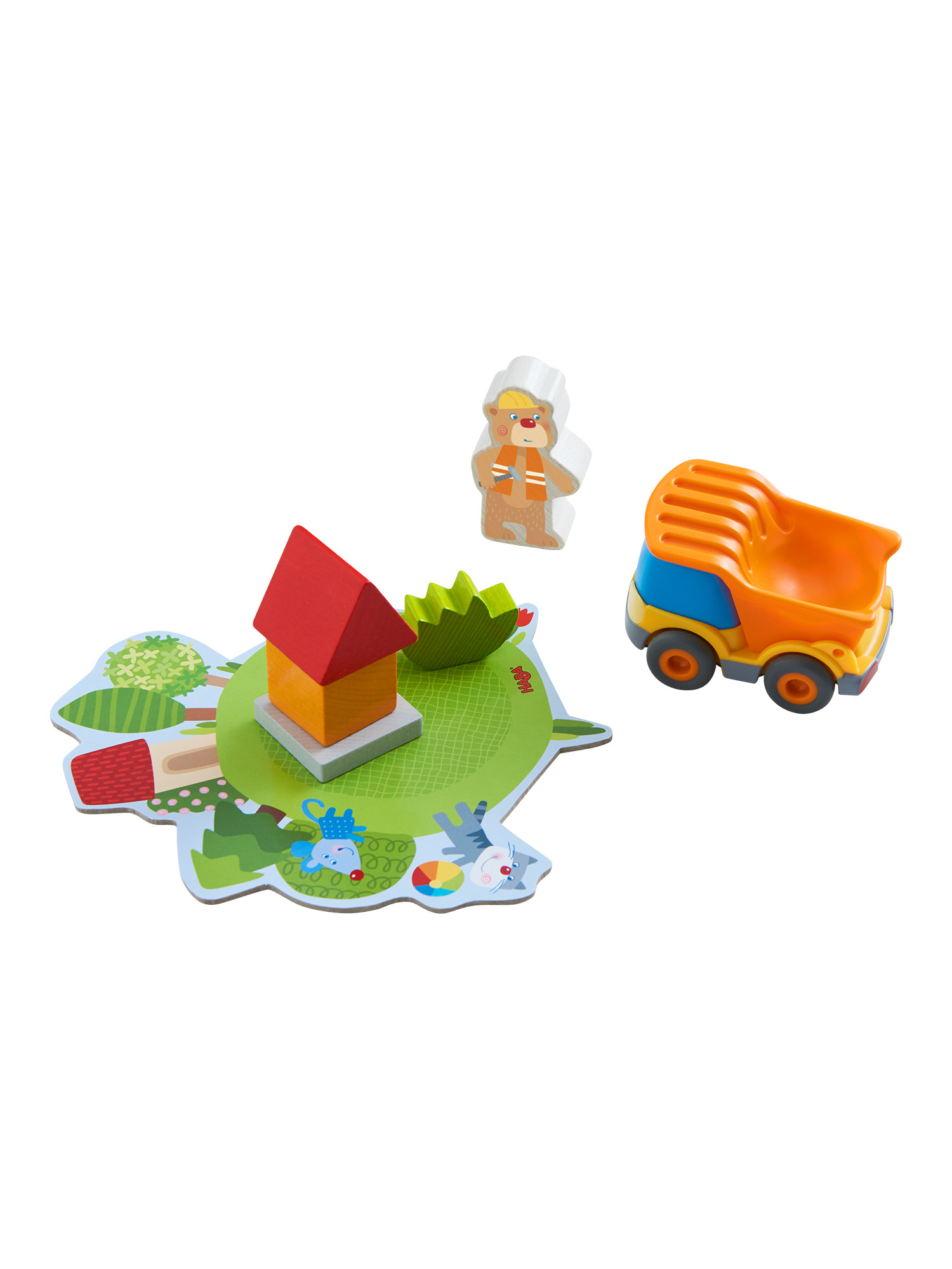 Spielzeugszene aus Holz mit einem Haus, einem Lastwagen und zwei Figuren auf grüner Basis mit weißem Hintergrund.
