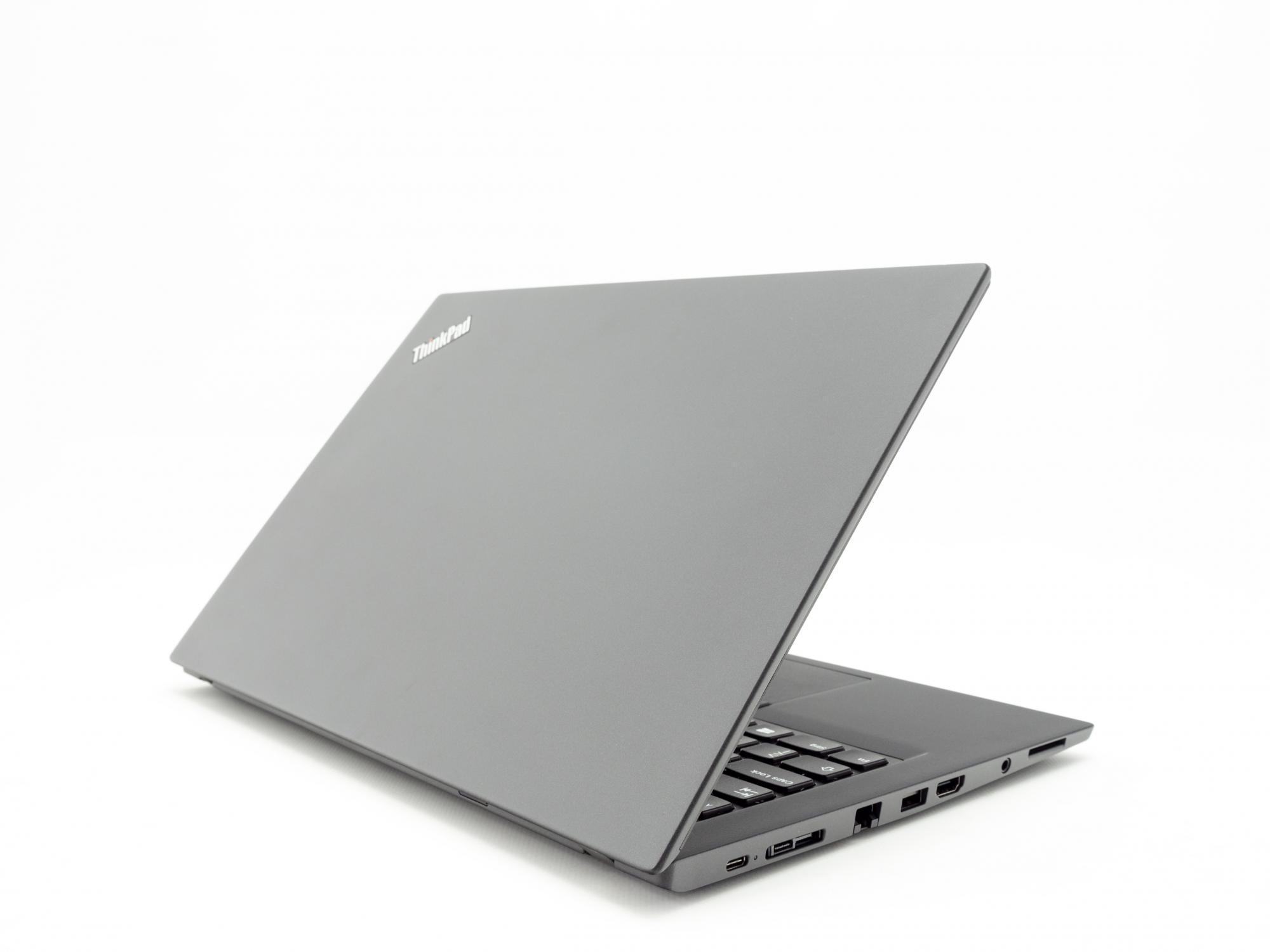 Ein grauer Laptop steht geöffnet auf einer weißen Oberfläche und ist so abgewinkelt, dass die Tastatur zu sehen ist.
