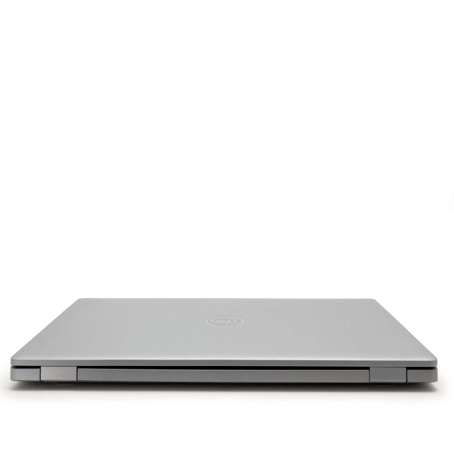 Geschlossener silberner Laptop auf einer weißen Oberfläche. Das Dell-Logo befindet sich in der Mitte des Deckels.