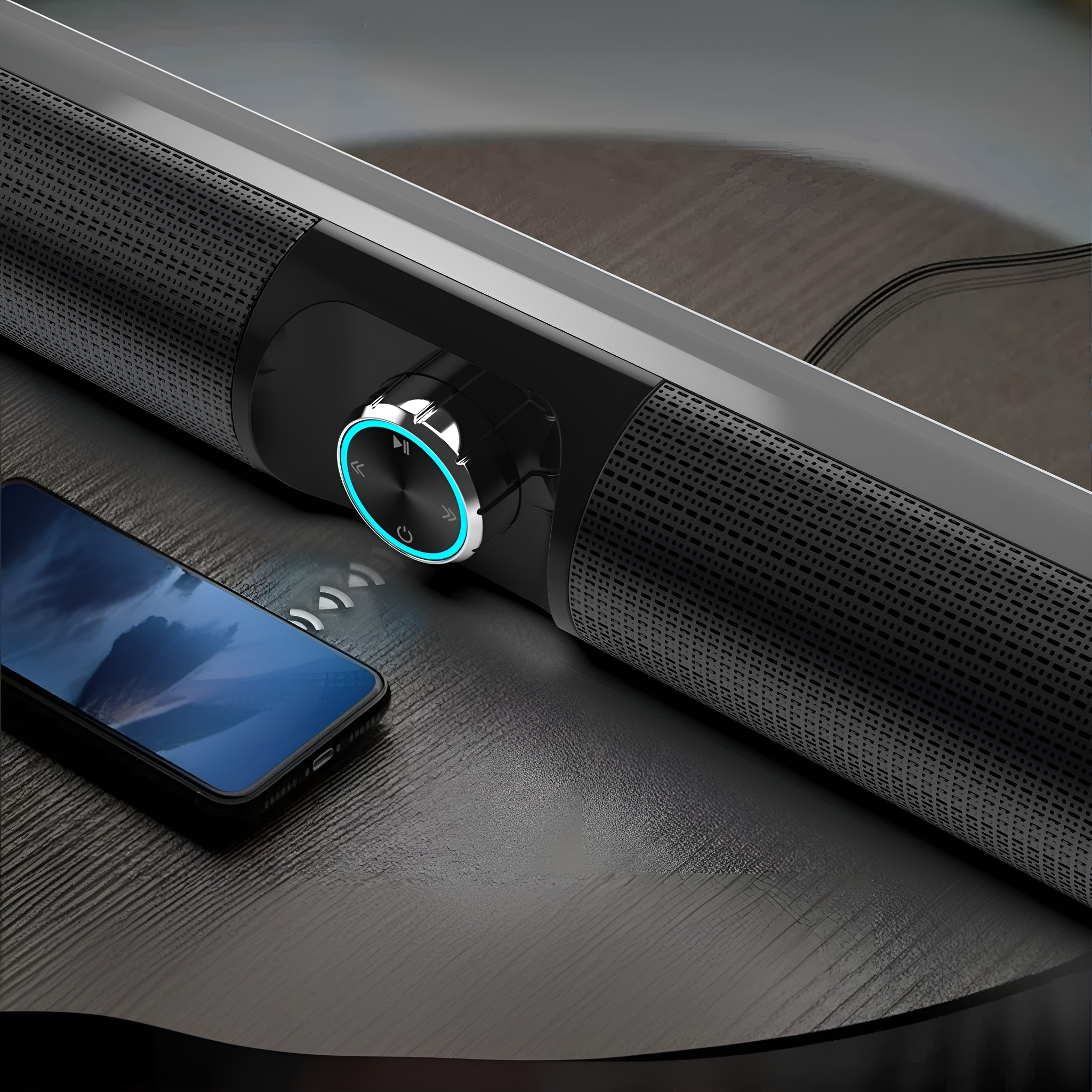 Eine schwarze Soundbar mit Lautstärkeregler und einem Telefon, das eine Musikoberfläche anzeigt.