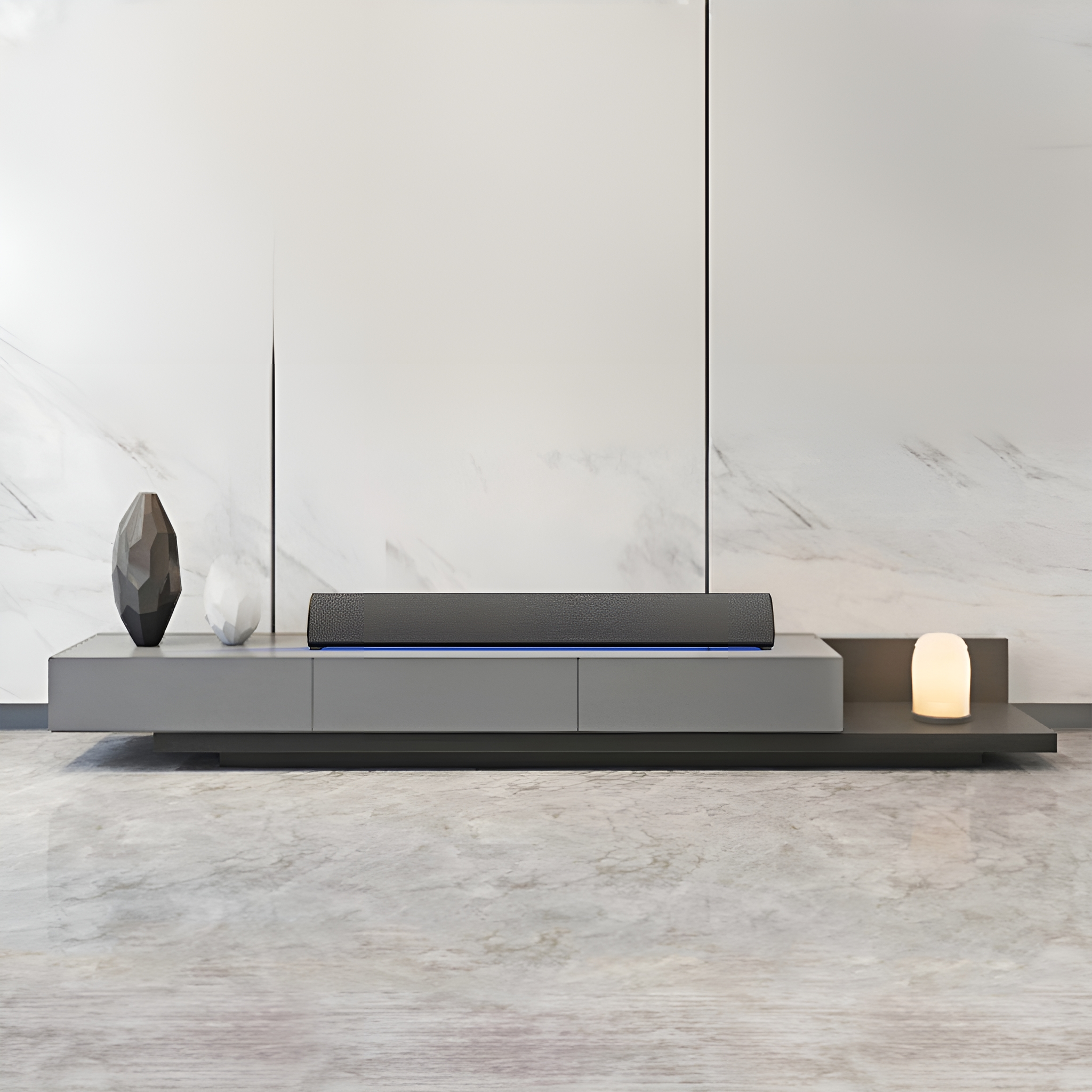 Moderner grauer TV-Ständer mit Soundbar und Dekorationen. Weiße Marmorwand und polierter Boden.