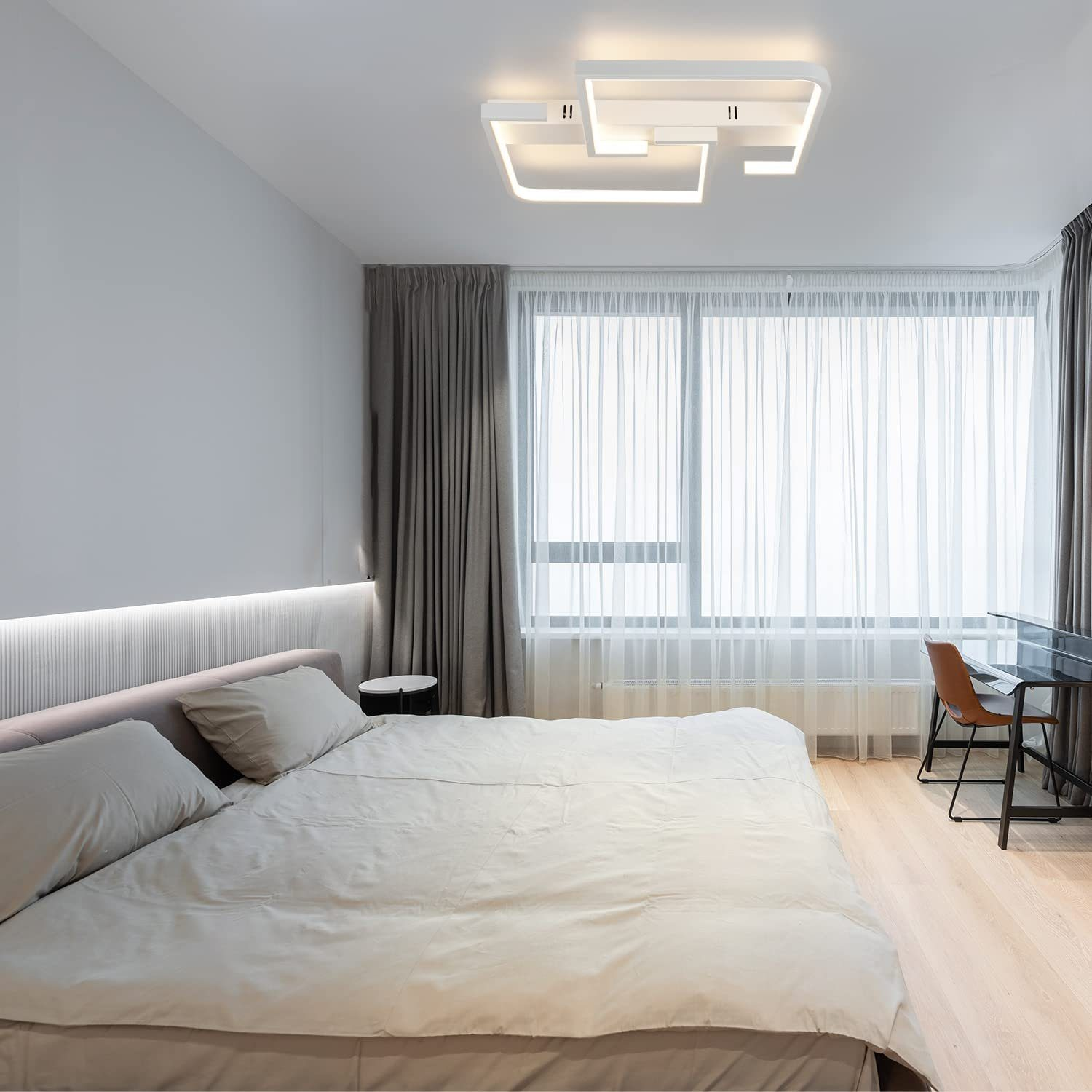 Una camera da letto con letto, tende e luce a soffitto. Il letto ha cuscini e una coperta. Pavimento in legno.