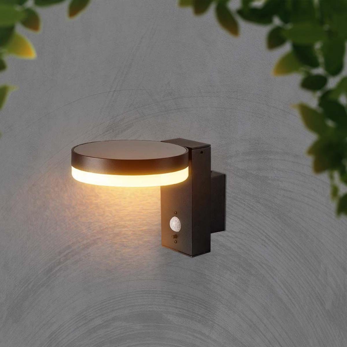 Wandleuchte mit Sensor. Dunkler Hintergrund, Blätter oben.