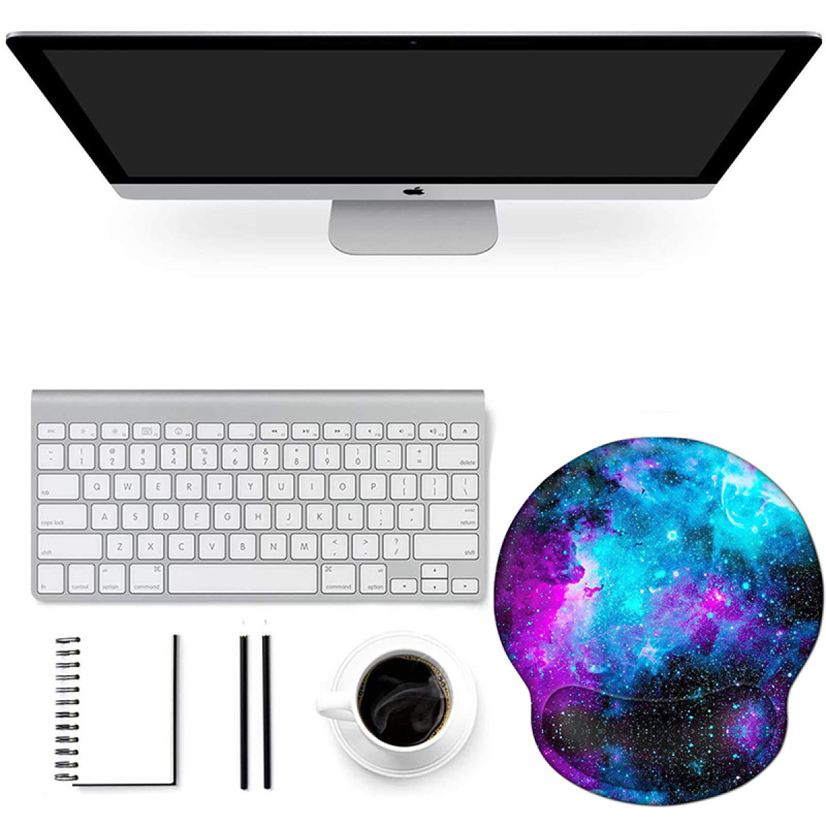 Ein Computer-Setup mit Monitor, Tastatur, Mauspad, Notizbuch und Kaffeetasse.