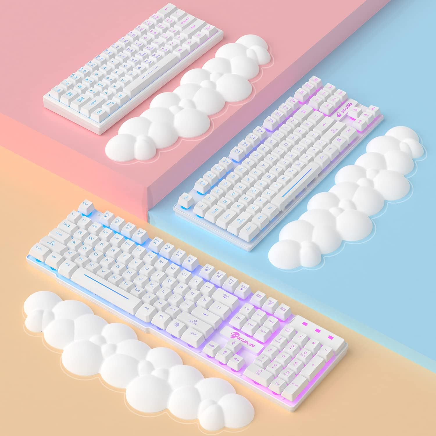 Trois claviers blancs avec repose-poignets en forme de nuage. Fond rose et bleu pastel.