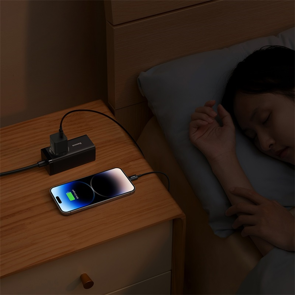 Persona durmiendo con teléfono cargando en mesita de noche con bloque de carga.
