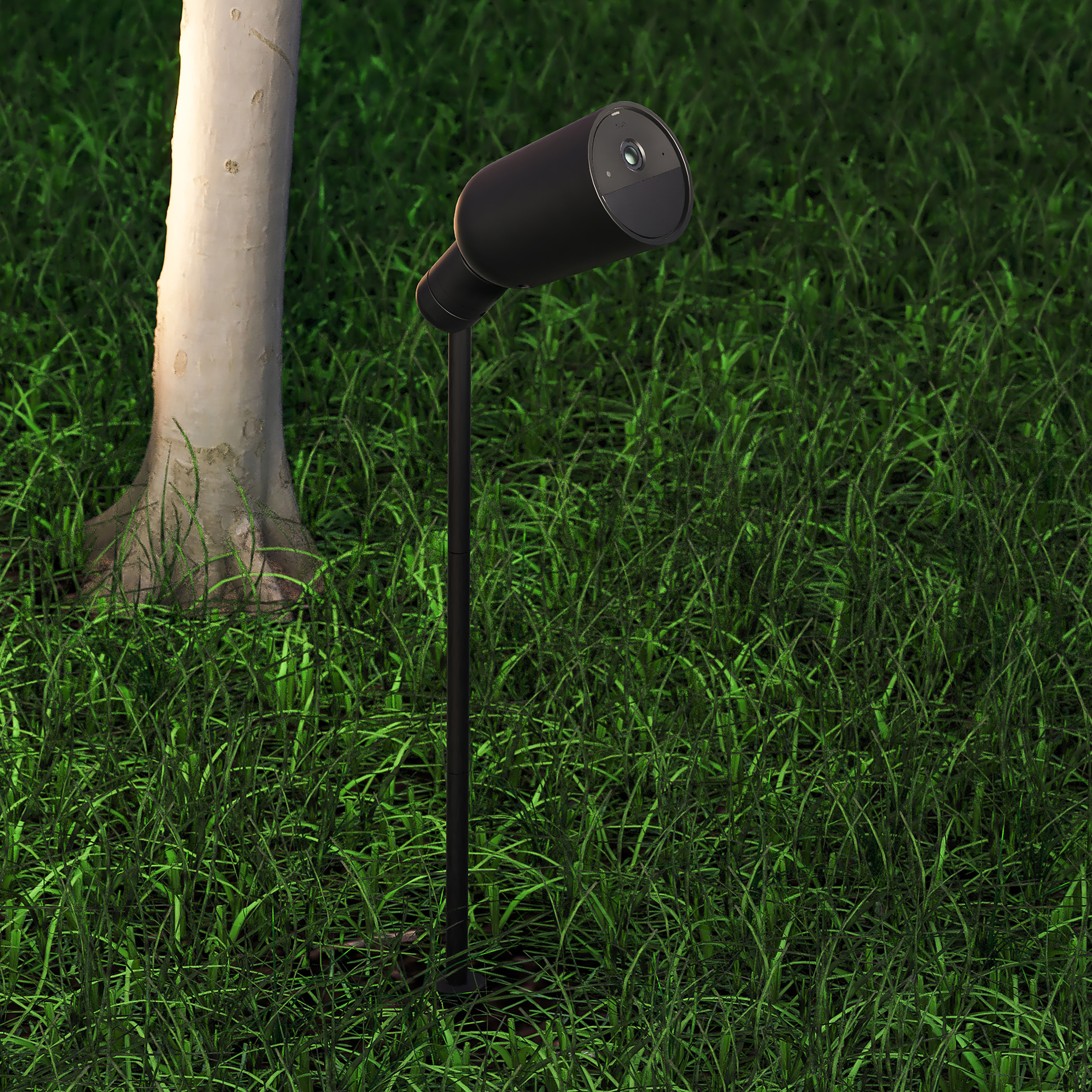Zwarte cilindrische buitenlamp op een standaard, in groen gras naast een boom.