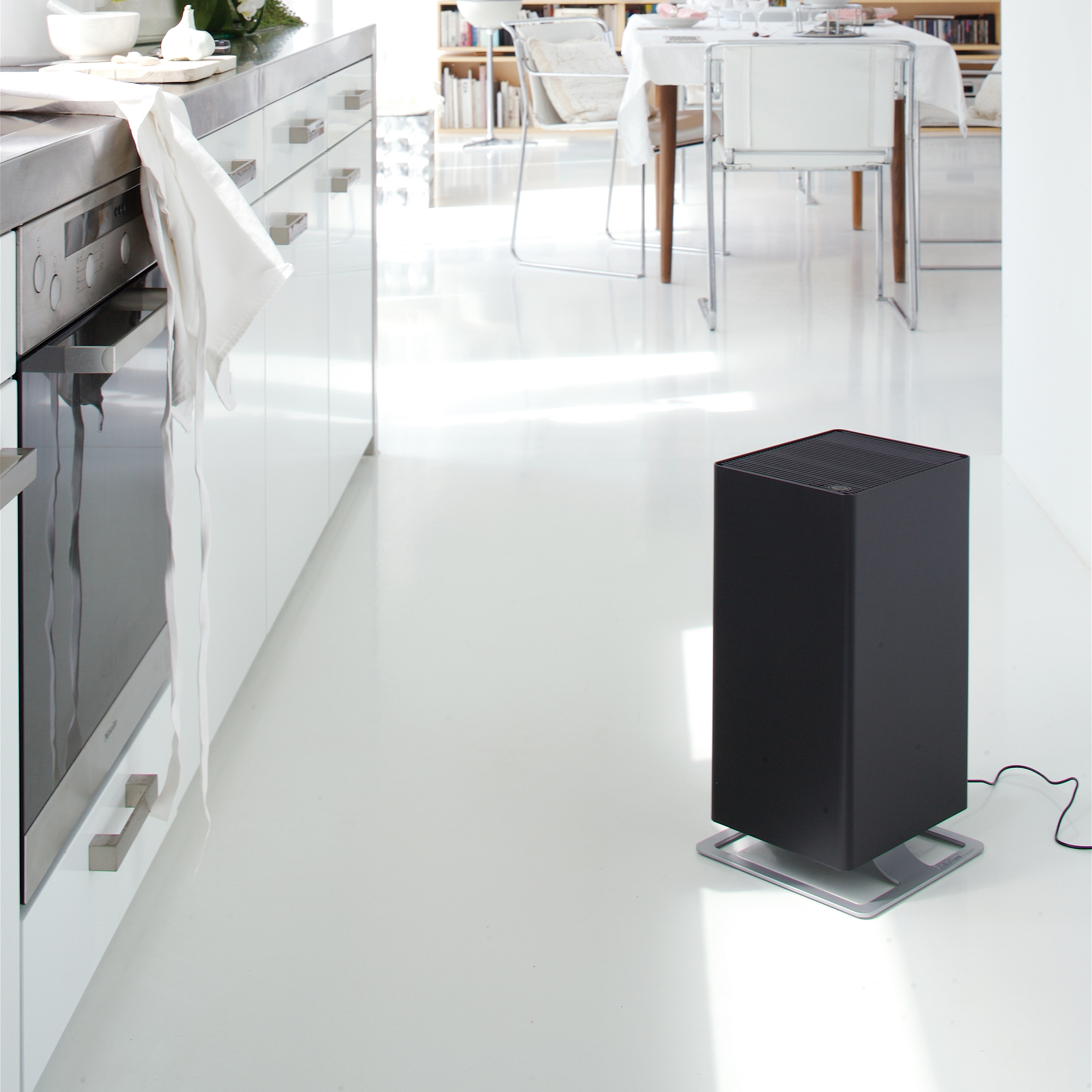 Purificatore d'aria nero su pavimento bianco in un ambiente cucina.
