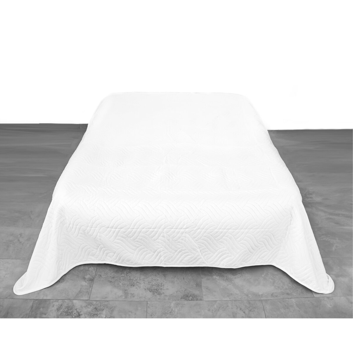 Eine weiße Bettdecke auf einem Bett. Die Decke hat ein gestepptes Muster.