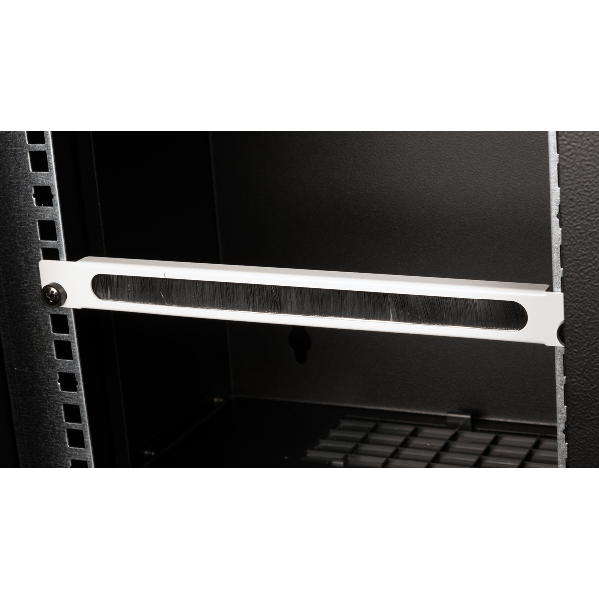 Pannello rack nero con spazzola. All'interno di un armadio rack. Sfondo nero.