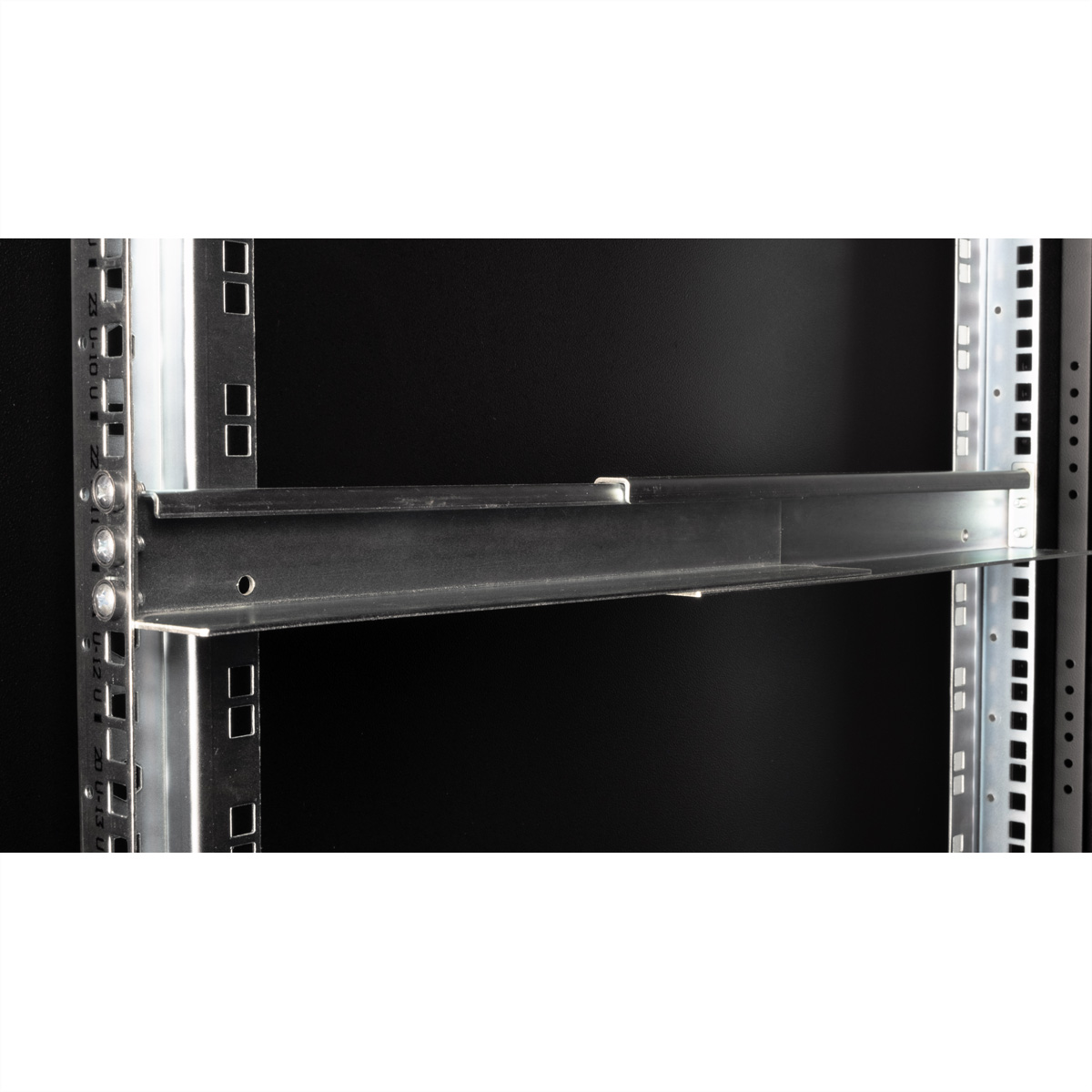 Guida rack in metallo. All'interno di un rack server. Sfondo nero.