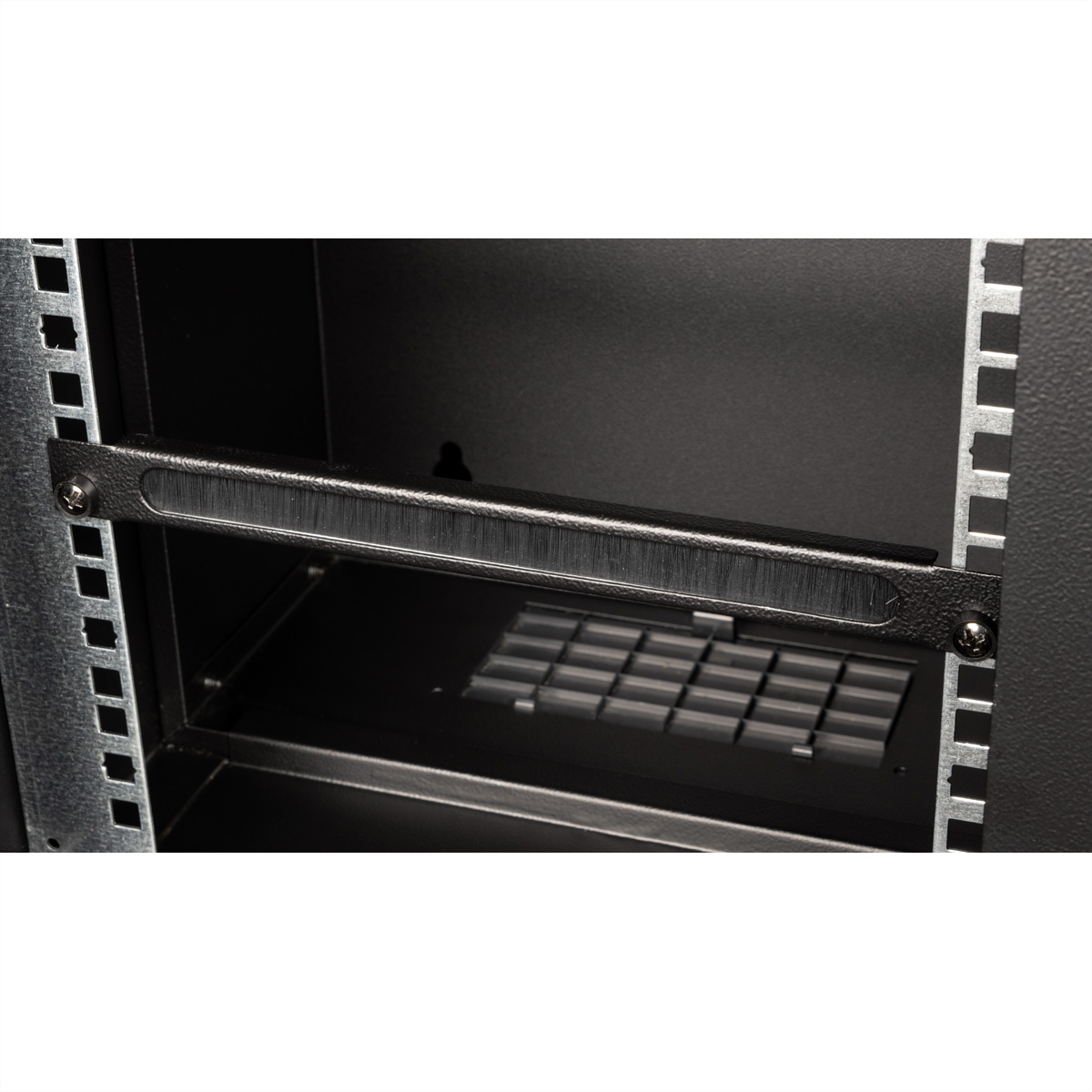 All'interno di un armadio rack nero. Una barra metallica con una spazzola davanti a una presa d'aria.