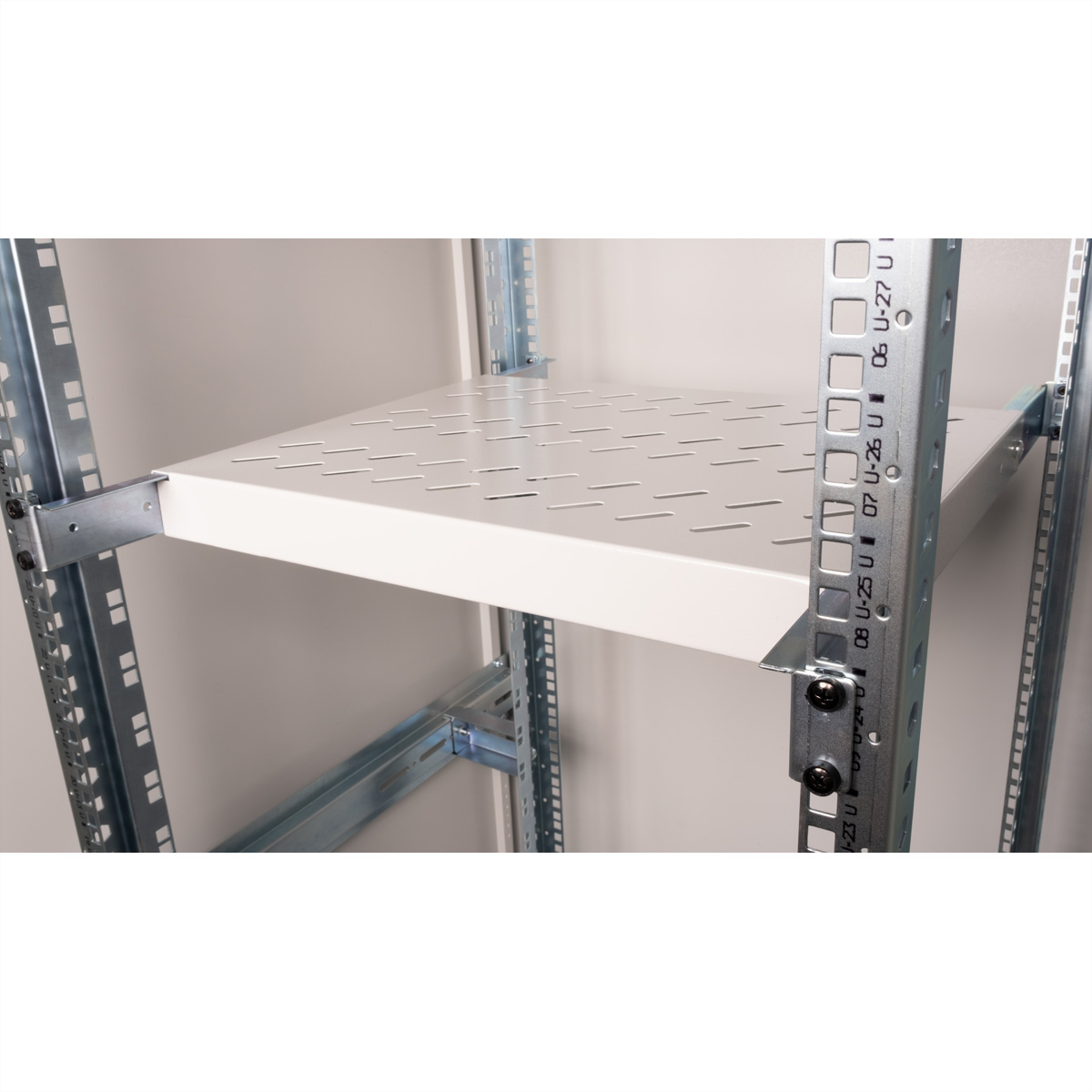 Ripiano in metallo bianco all'interno di un rack server, con intagli e punti di montaggio.