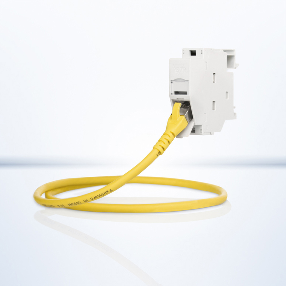 Un cavo ethernet giallo collegato a un componente elettrico bianco.