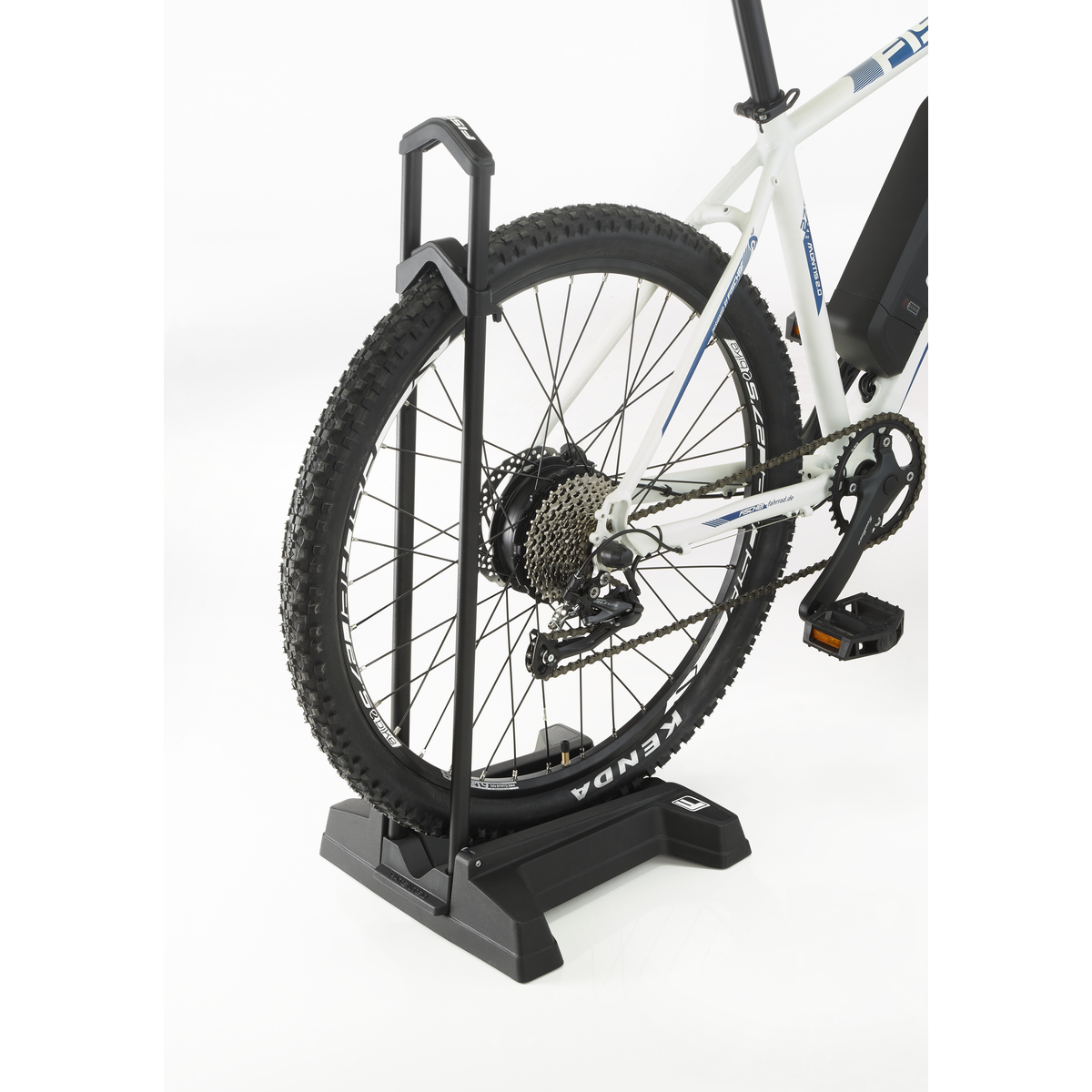 Ein Fahrrad mit schwarz-weißem Rahmen wird von einem schwarzen Fahrradständer gehalten.