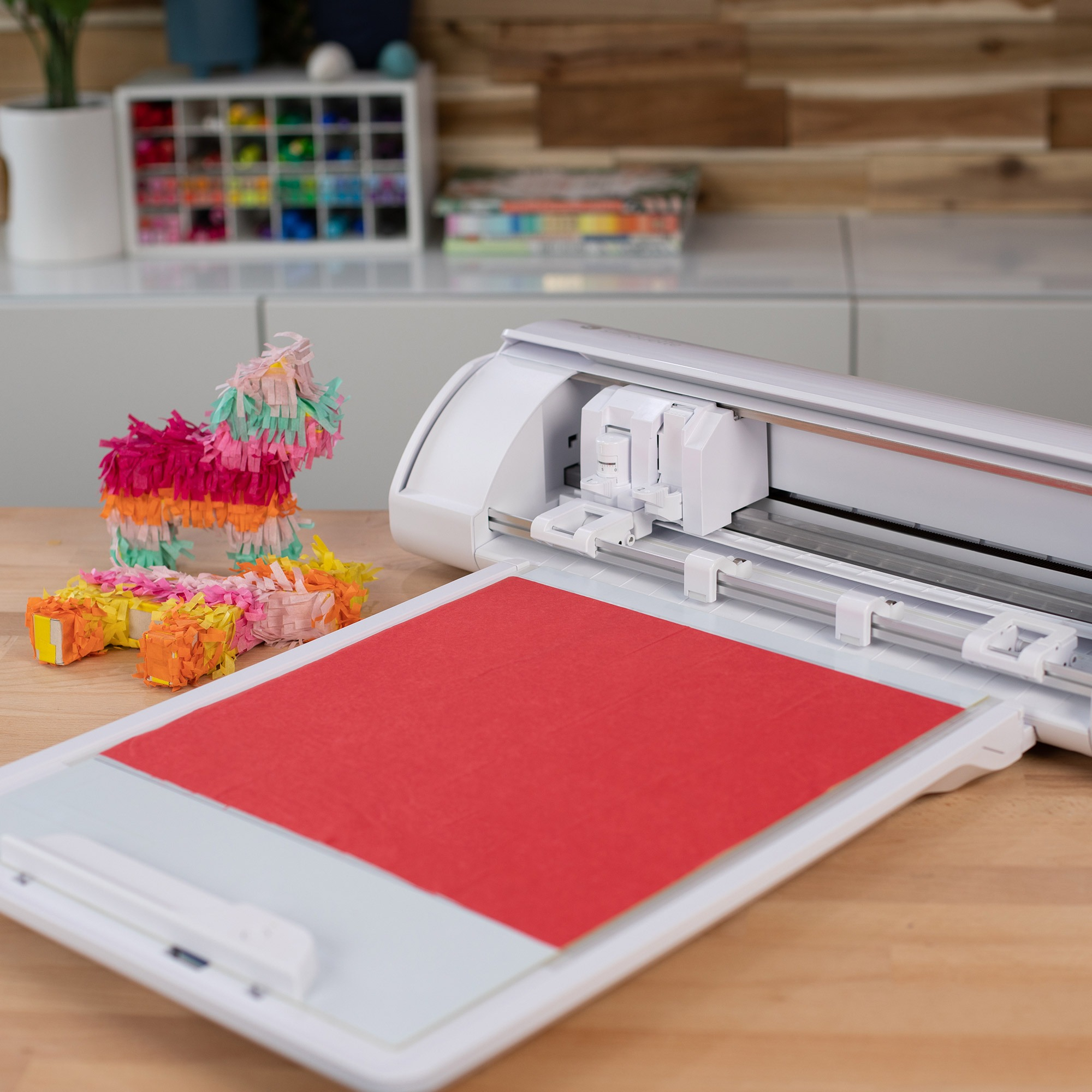Weiße Schneidemaschine, rotes Papier und eine Piñata.