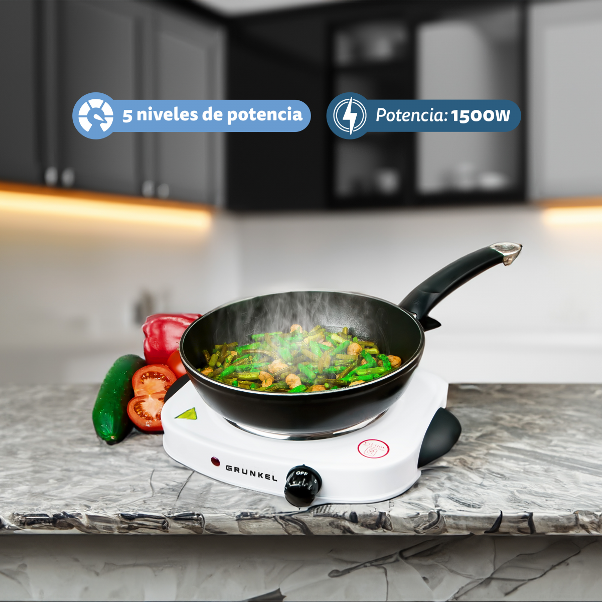 Sartén eléctrica con comida cocinándose. Verduras y tomate en la encimera.