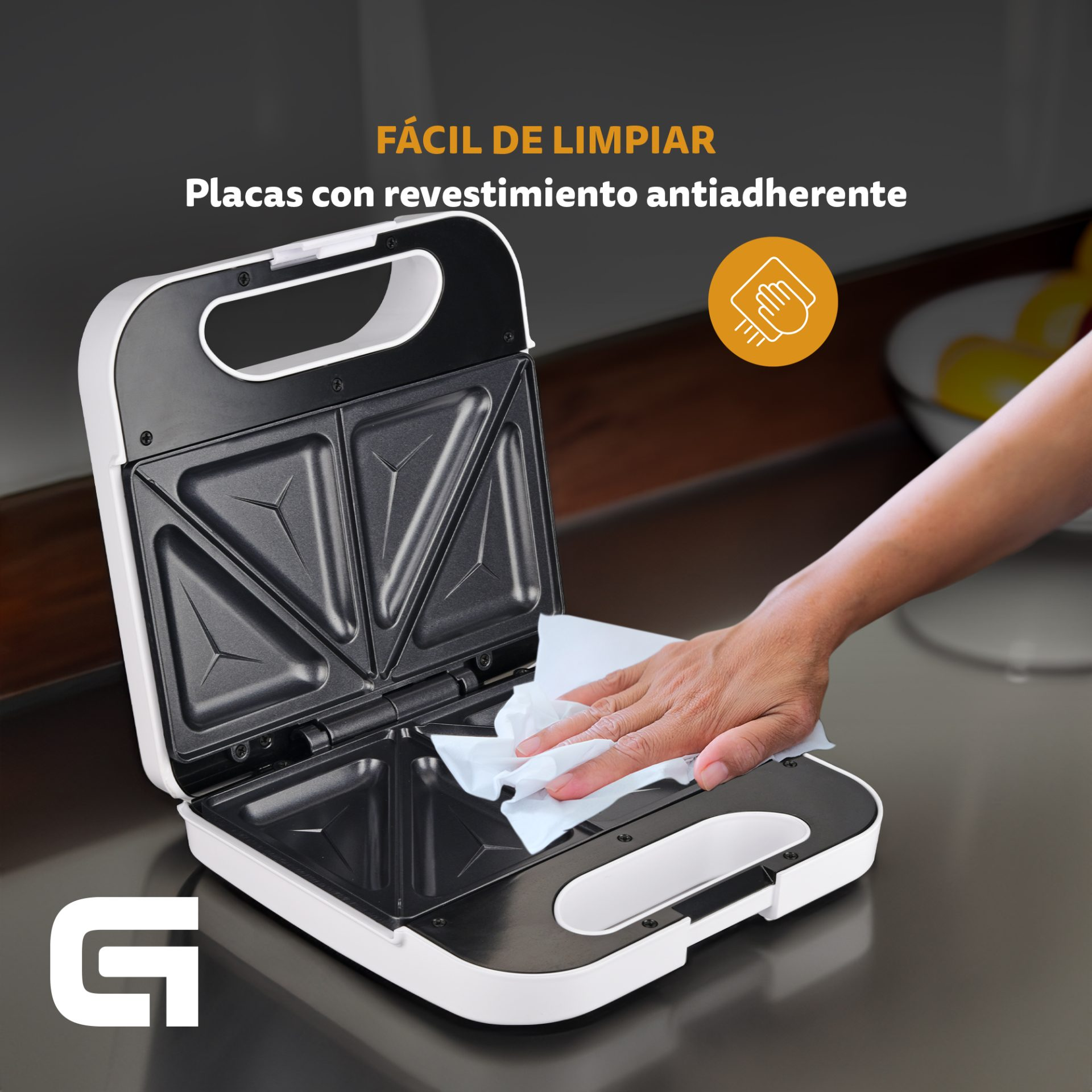 Sandwichera con tapa abierta, mano limpiándola con un paño, texto: fácil de limpiar, antiadherente.