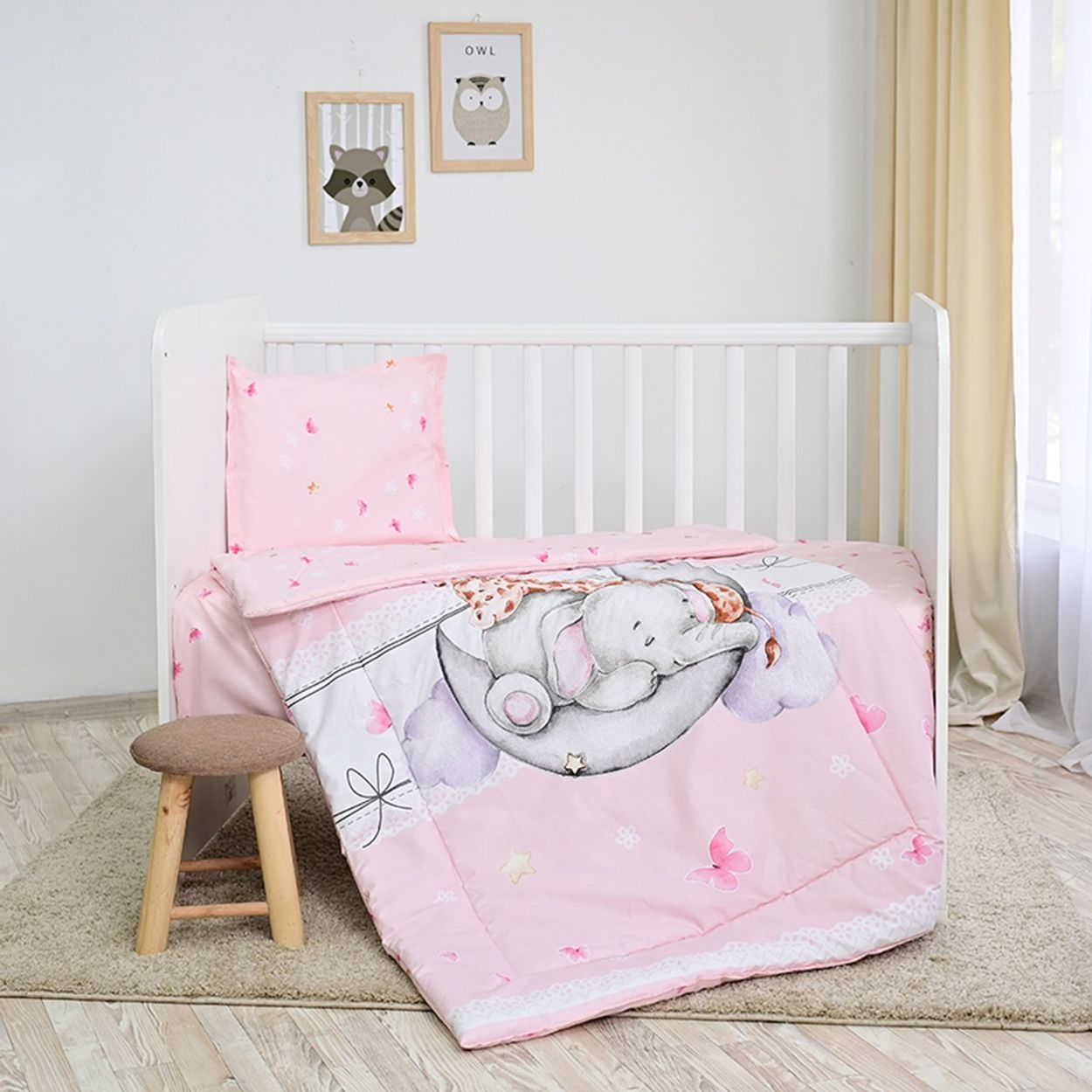 Rosa Babybettwäsche mit Elefantenmuster, Kissen und kleinem Holzschemel, mit Wandkunst.