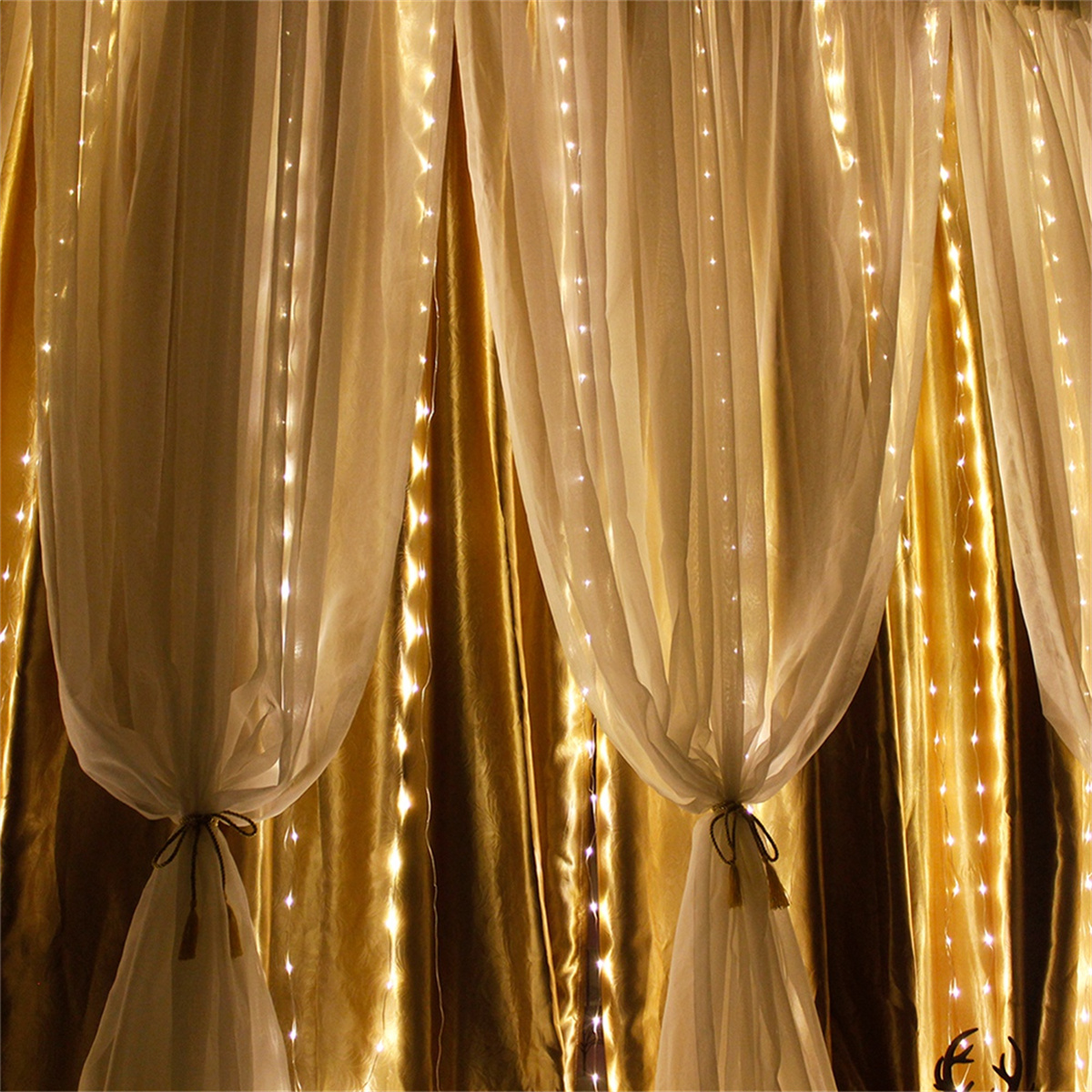Goldene Stoffvorhänge mit weißem, transparentem Überzug, Lichterketten.