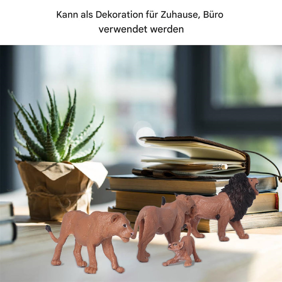 Eine Sammlung von Spielzeuglöwen und eine Pflanze auf einem Schreibtisch neben Büchern. Text auf Deutsch.