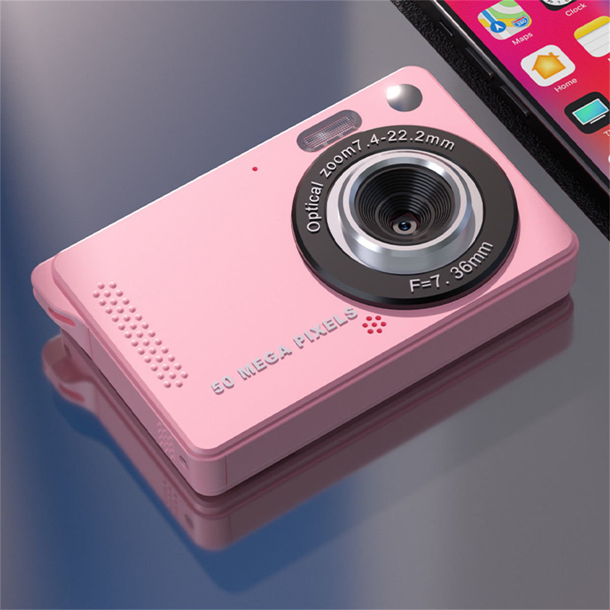 Eine rosa Kamera mit großem Objektiv, beschriftet mit '50 MEGA PIXEL', auf reflektierender Oberfläche.
