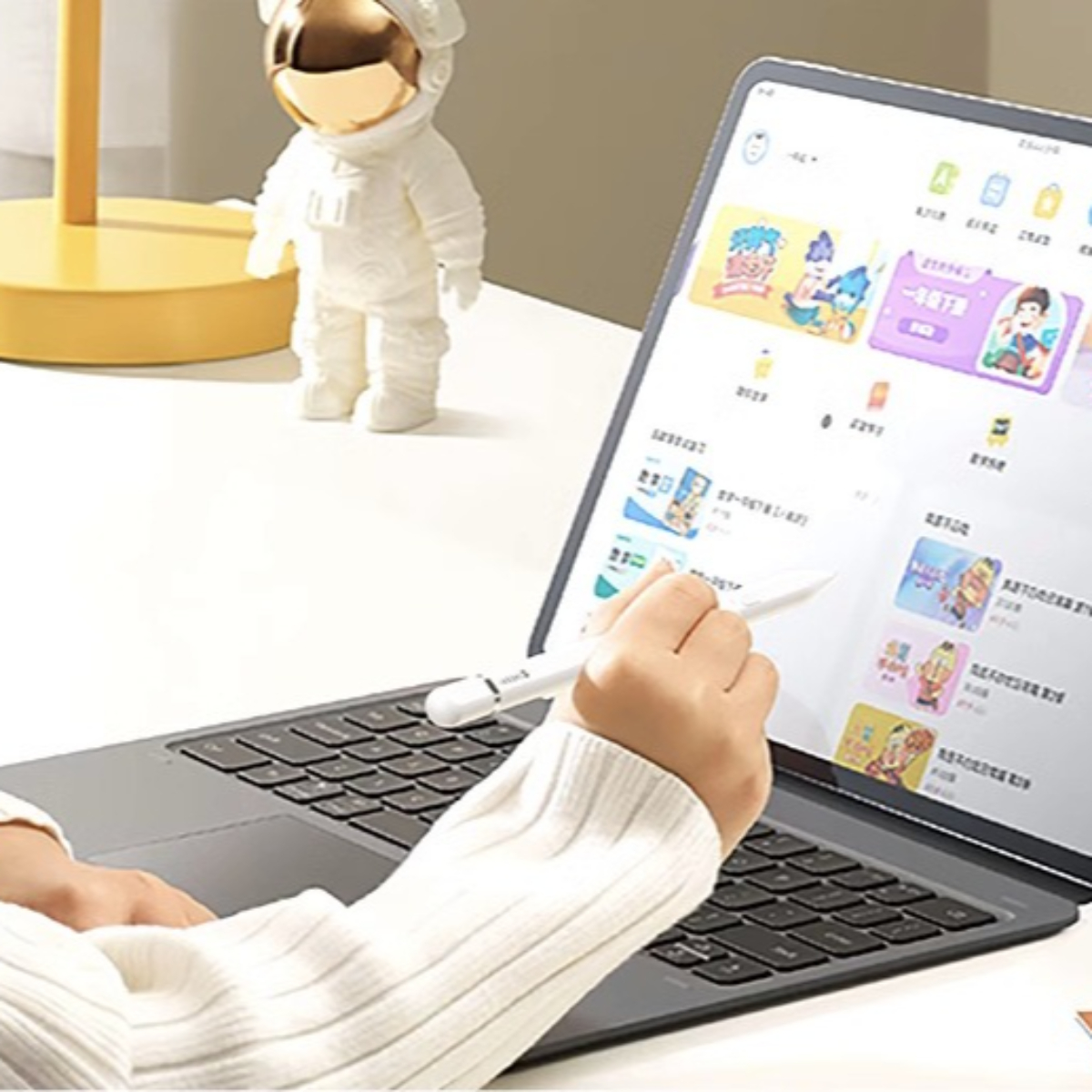 Eine Person, die ein Tablet mit einem Stift verwendet, mit einer Astronautenfigur in der Nähe.