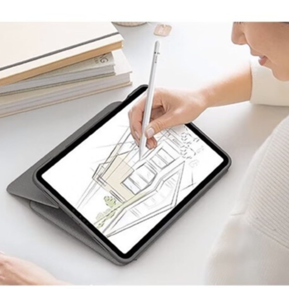 Eine Person, die einen Stift auf einem Tablet verwendet. Das Tablet zeigt eine Zeichnung, und es gibt ein Notizbuch.
