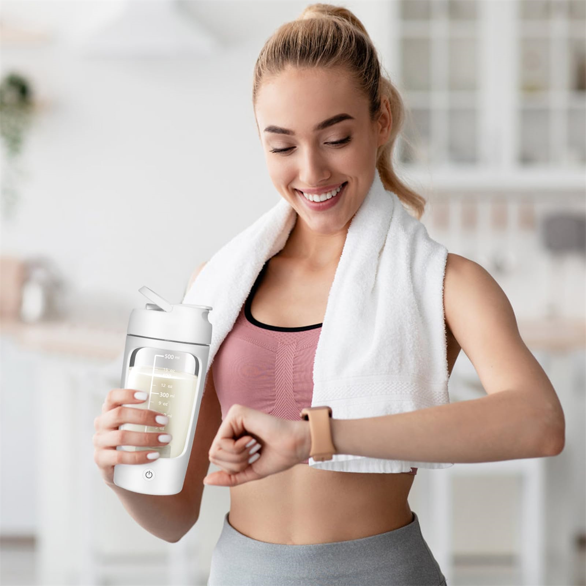 Frau hält eine weiße Shaker-Flasche, ein weißes Handtuch auf den Schultern, blickt auf ihre Uhr.