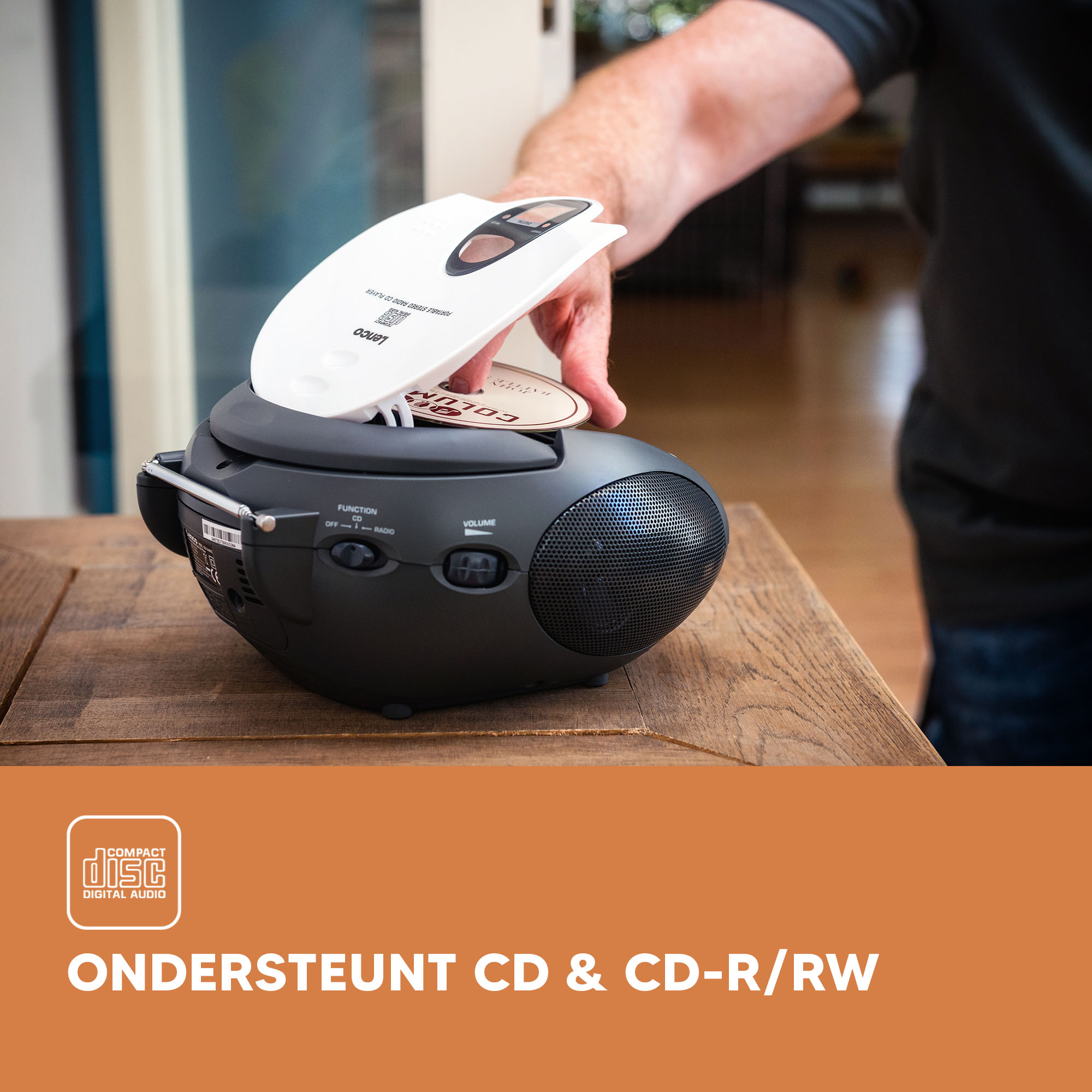 Black CD player with a CD being inserted. A hand is opening the CD tray.