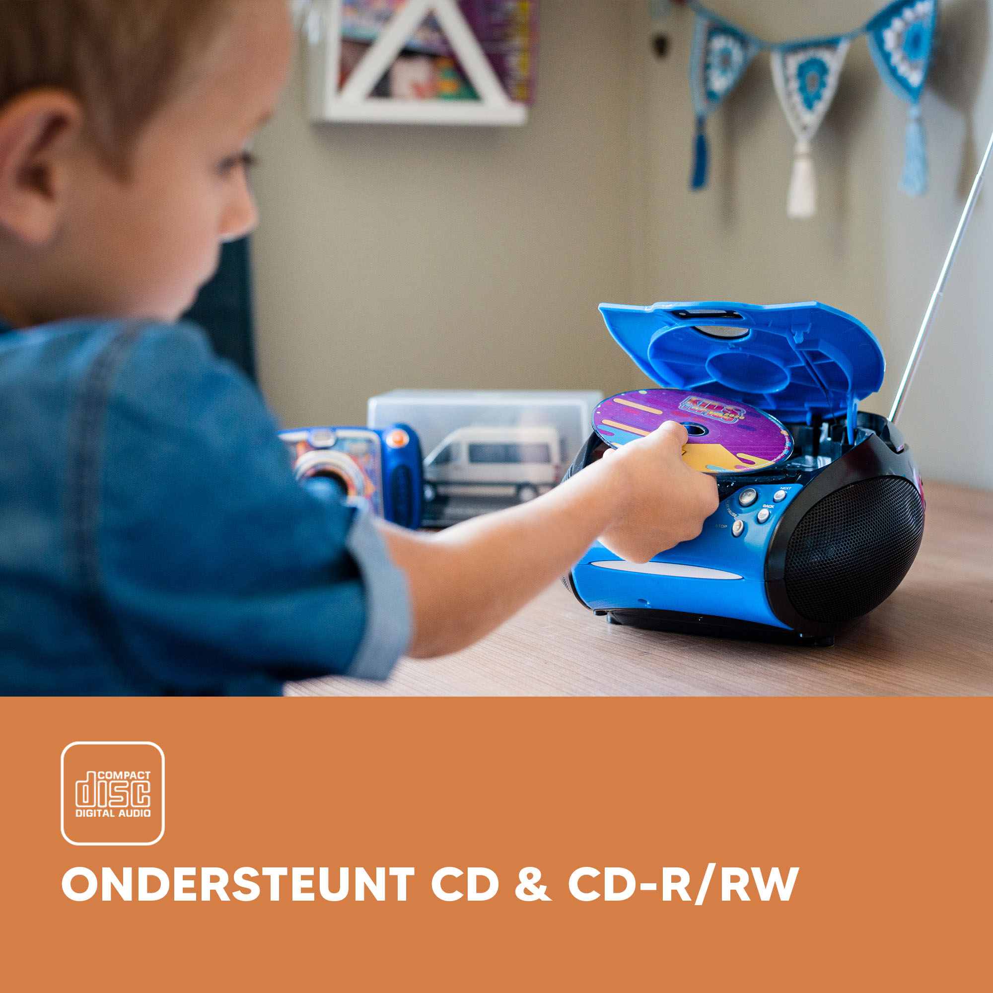 A child putting a CD into a blue boombox.