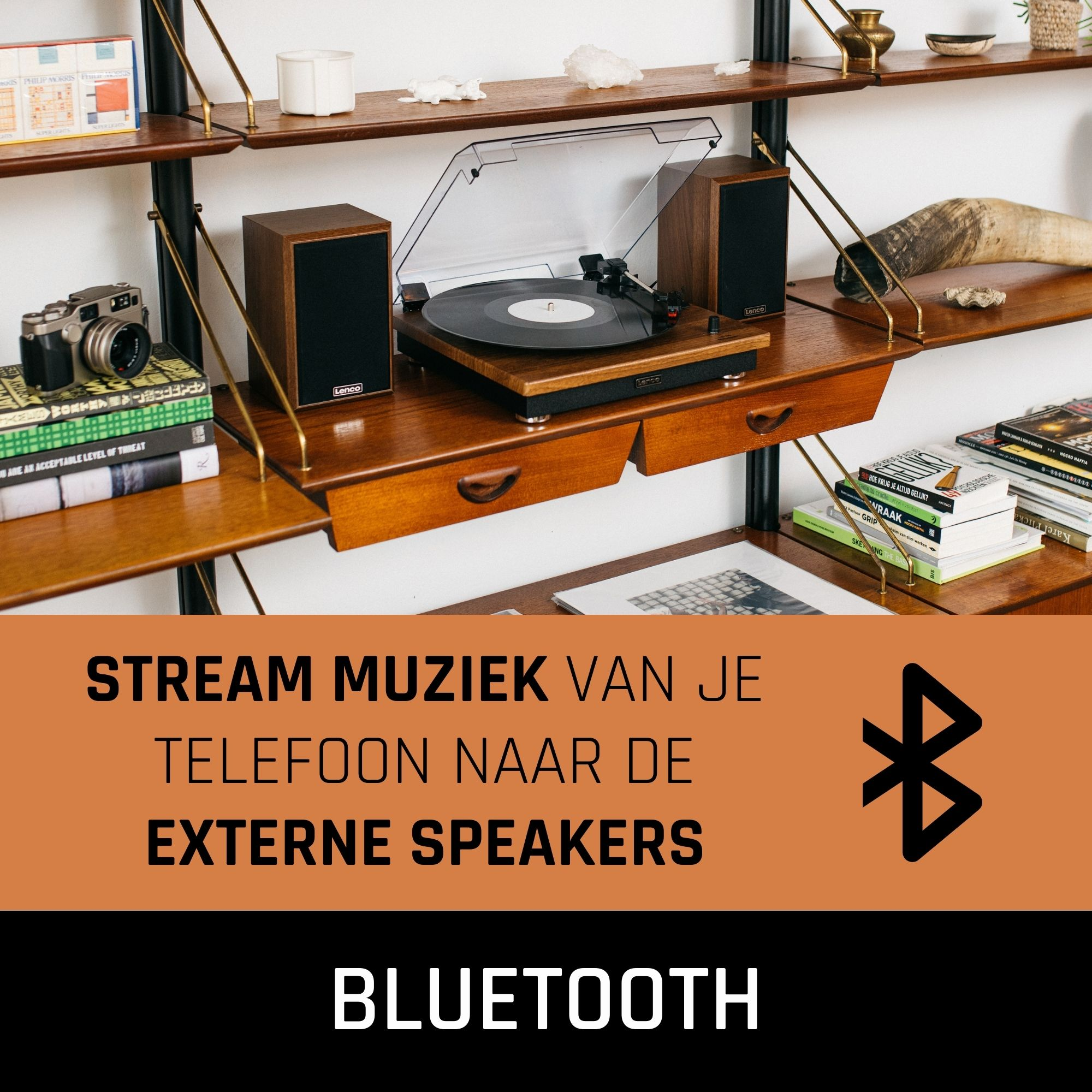 A record player with speakers on a shelf.