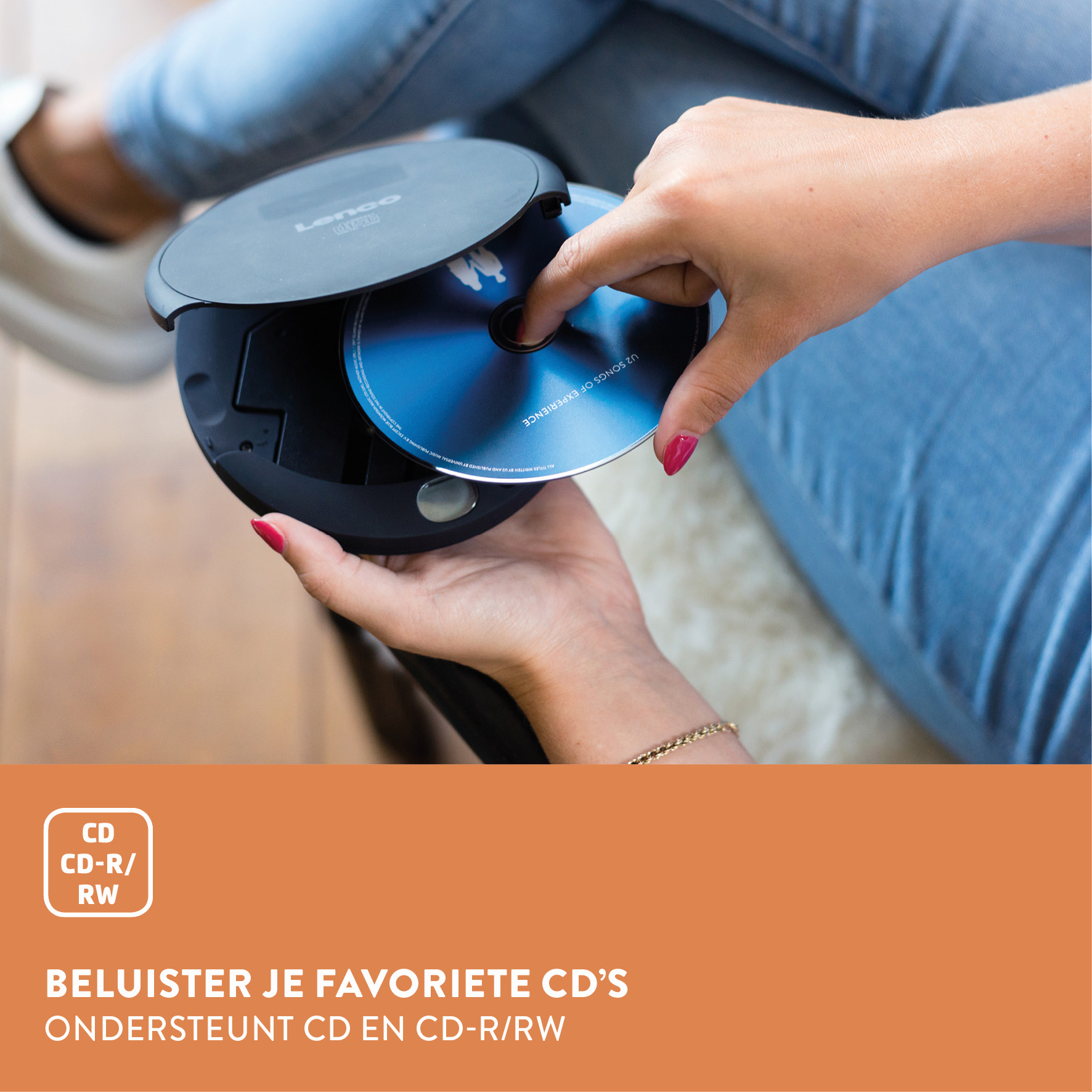 A person inserts a blue CD into a black CD player.