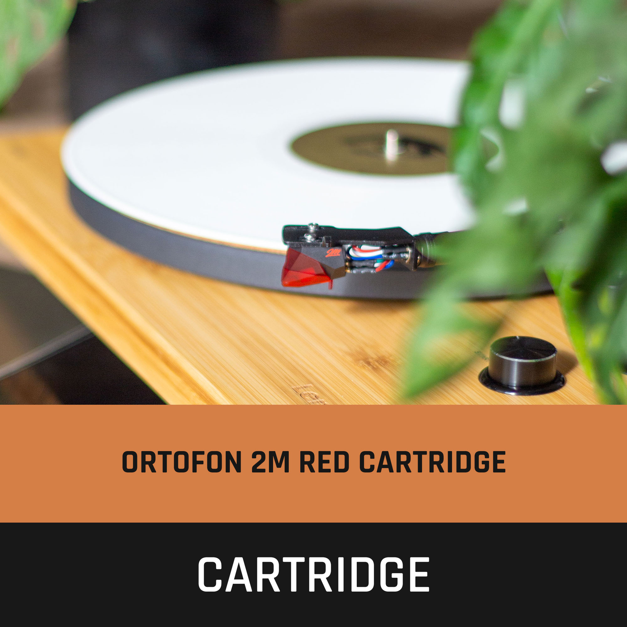 Platenspeler met witte plaat, rode cartridge en houten oppervlak. Focus op de cartridge.