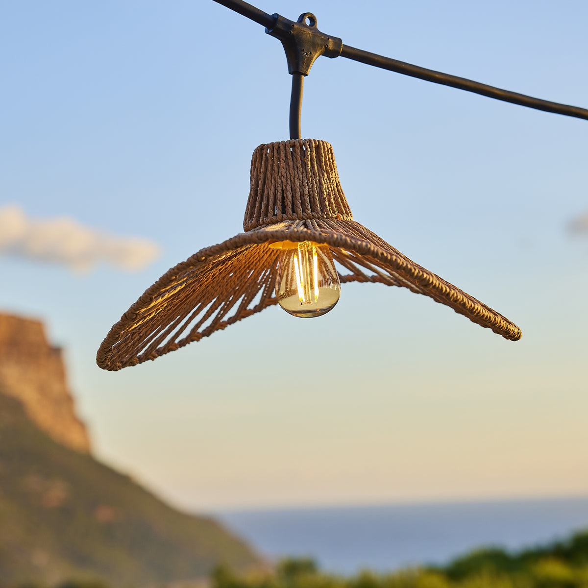 Hängende Außenleuchte mit einer Lampe und einem natürlich aussehenden Lampenschirm.