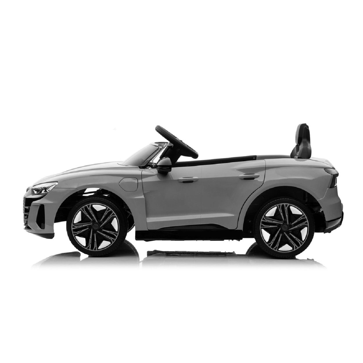 Graues Spielzeugauto mit schwarzen Rädern auf weißem Hintergrund. Es hat ein Lenkrad und einen kleinen Sitz.