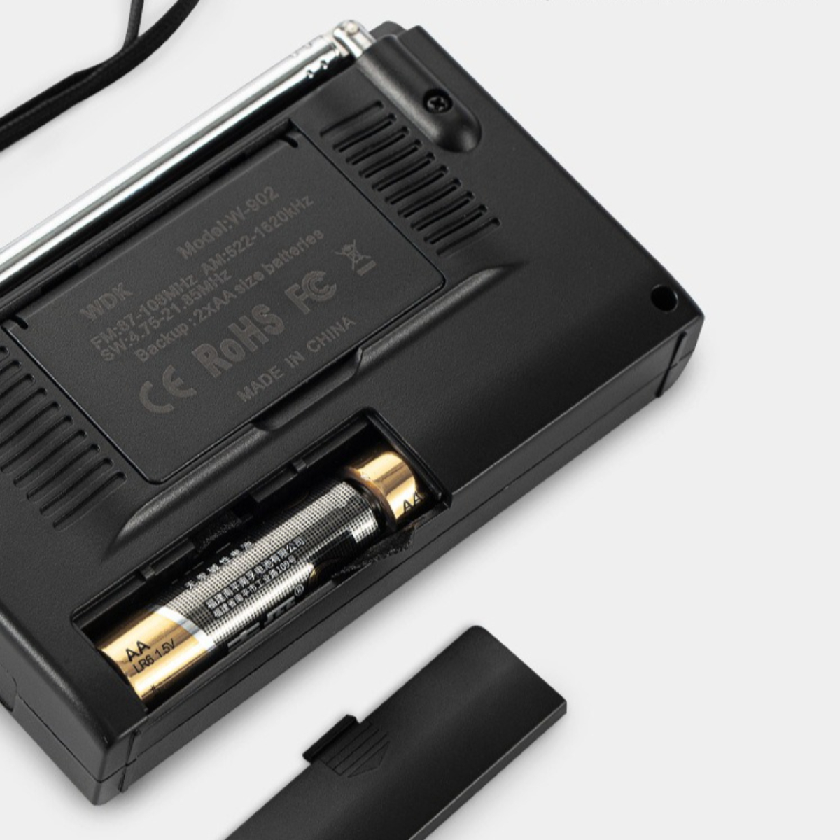 Schwarzes Radio, Rückansicht, mit offenem Batteriefach, das eine Batterie zeigt.