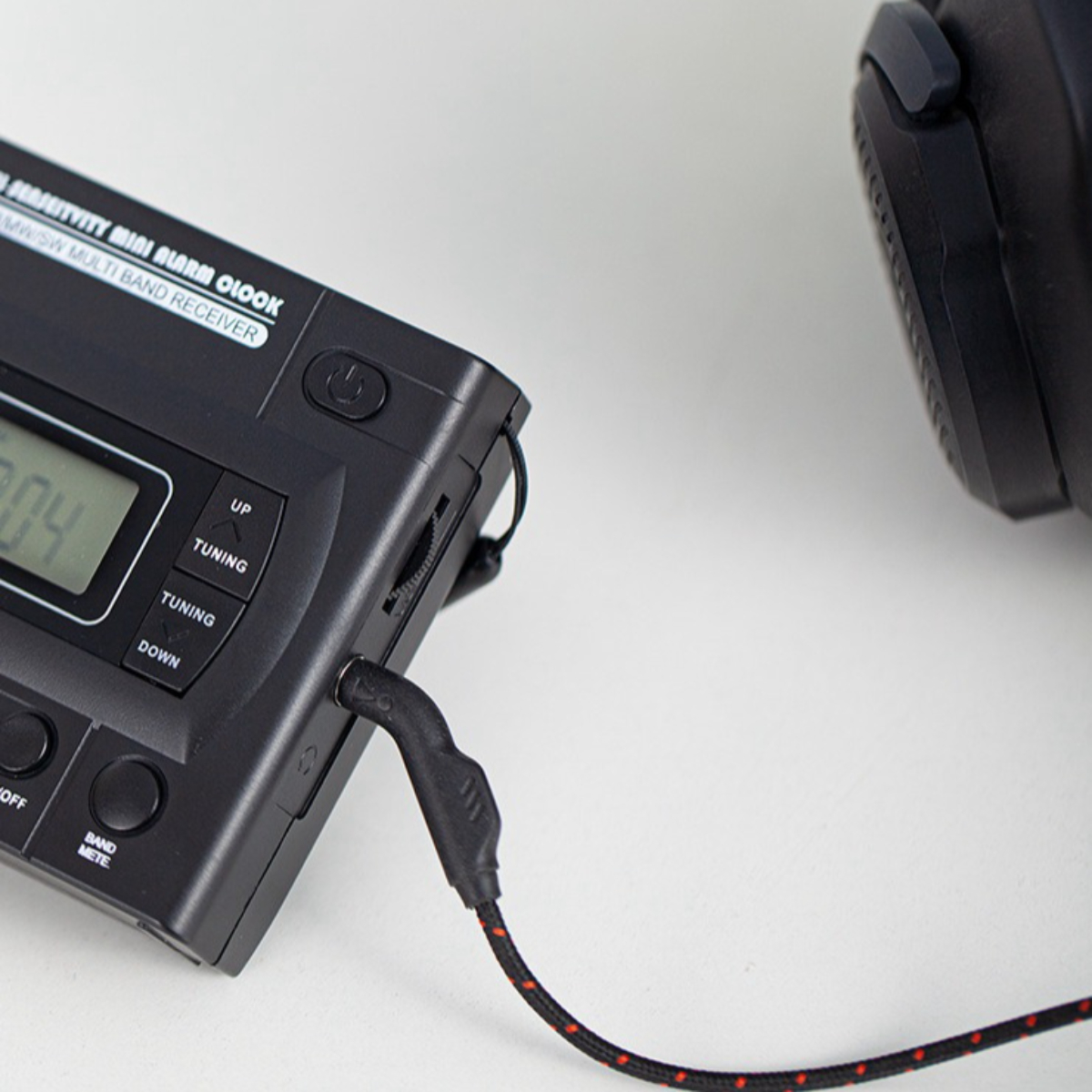 Schwarzes tragbares Radio mit angeschlossener Kopfhörerbuchse.
